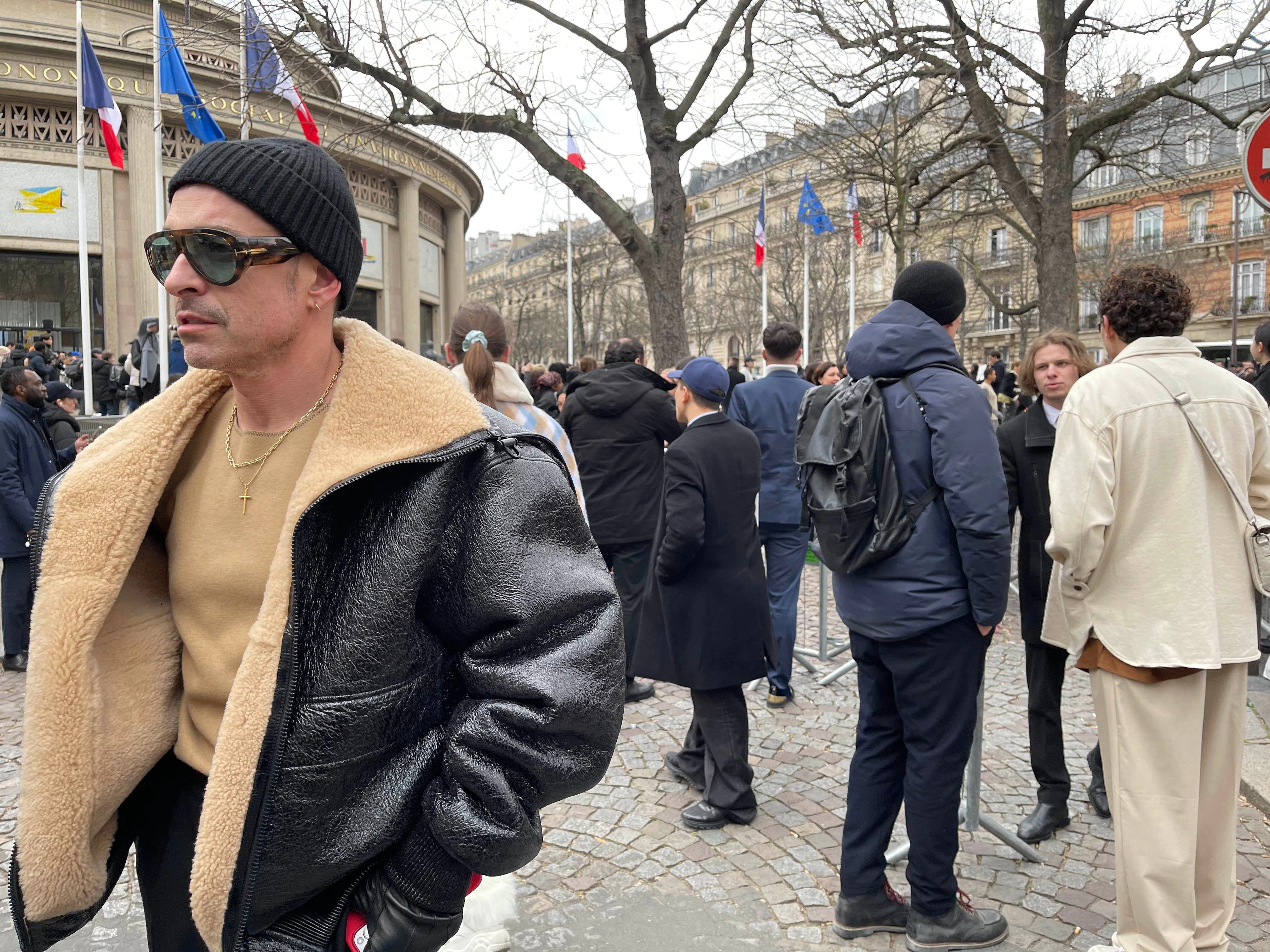 Ein Gast mit großer Sonnenbrille, Goldschmuck und üppiger Jacke.
