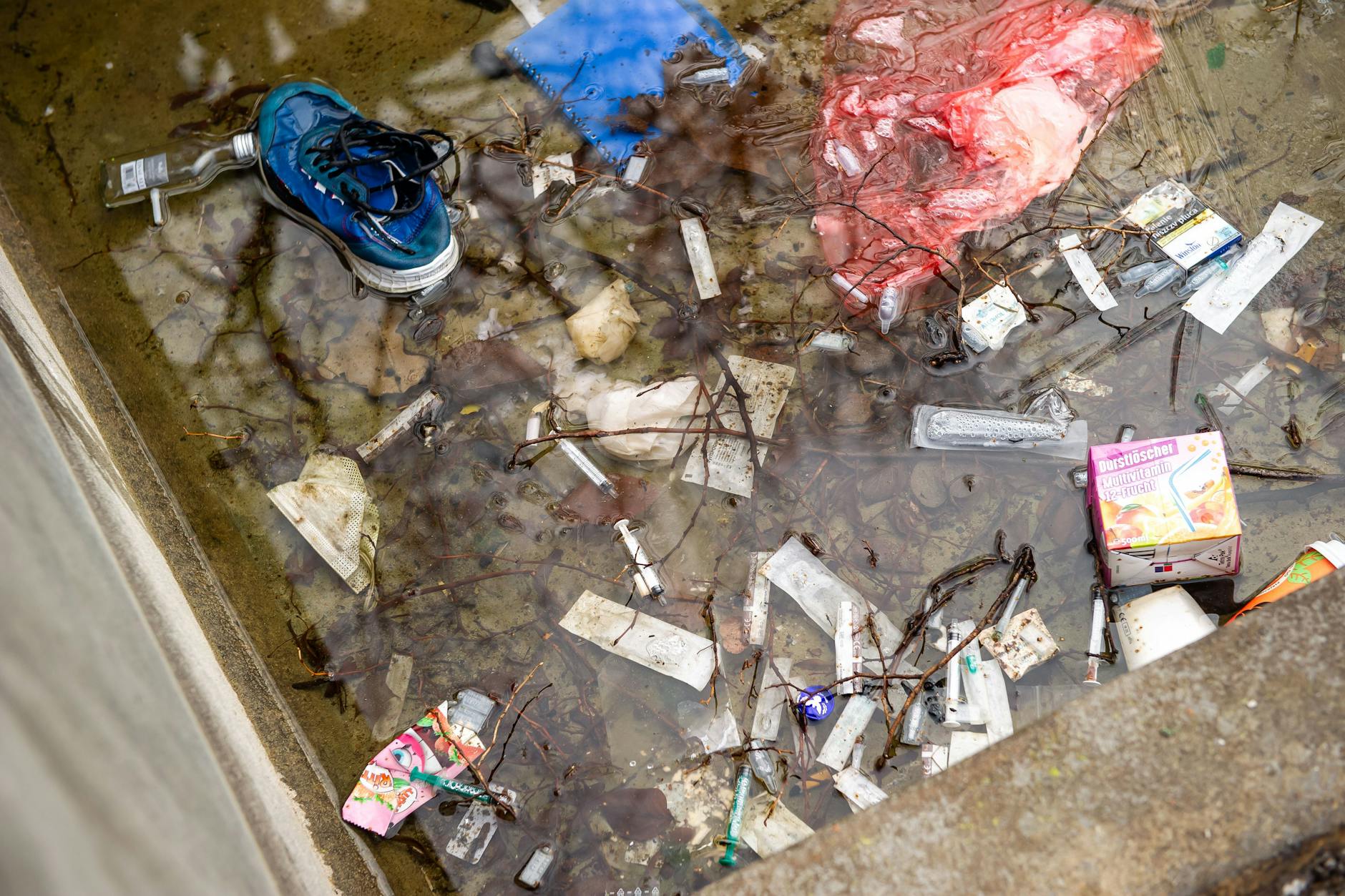 Spritzen und Drogenbehälter liegen im Wasserbecken des Körnerparks.