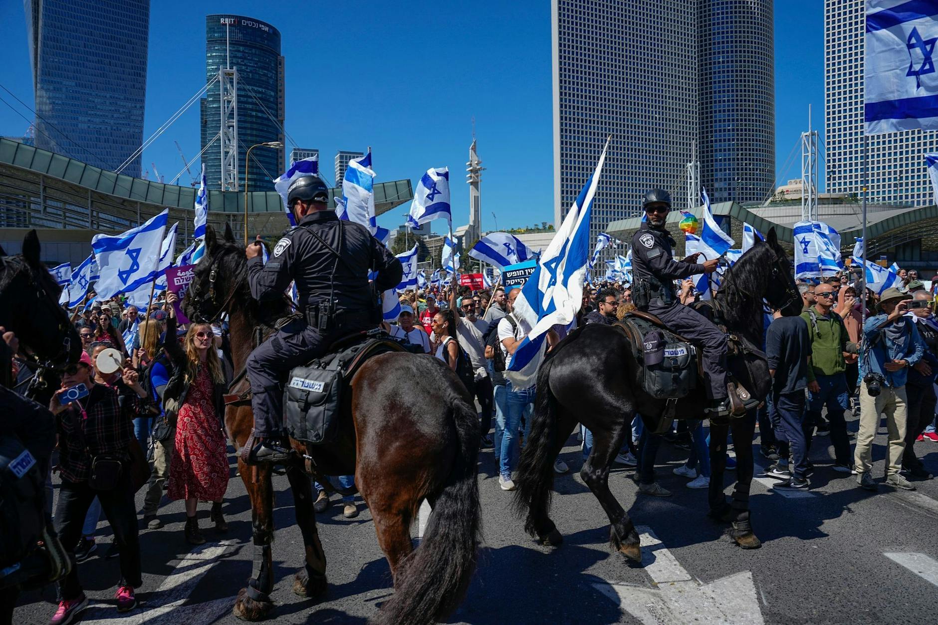 Berittene Polizisten werden eingesetzt, als Israelis eine Hauptstraße blockieren, um gegen die Pläne der Regierung von Ministerpräsident Netanjahu zu protestieren.