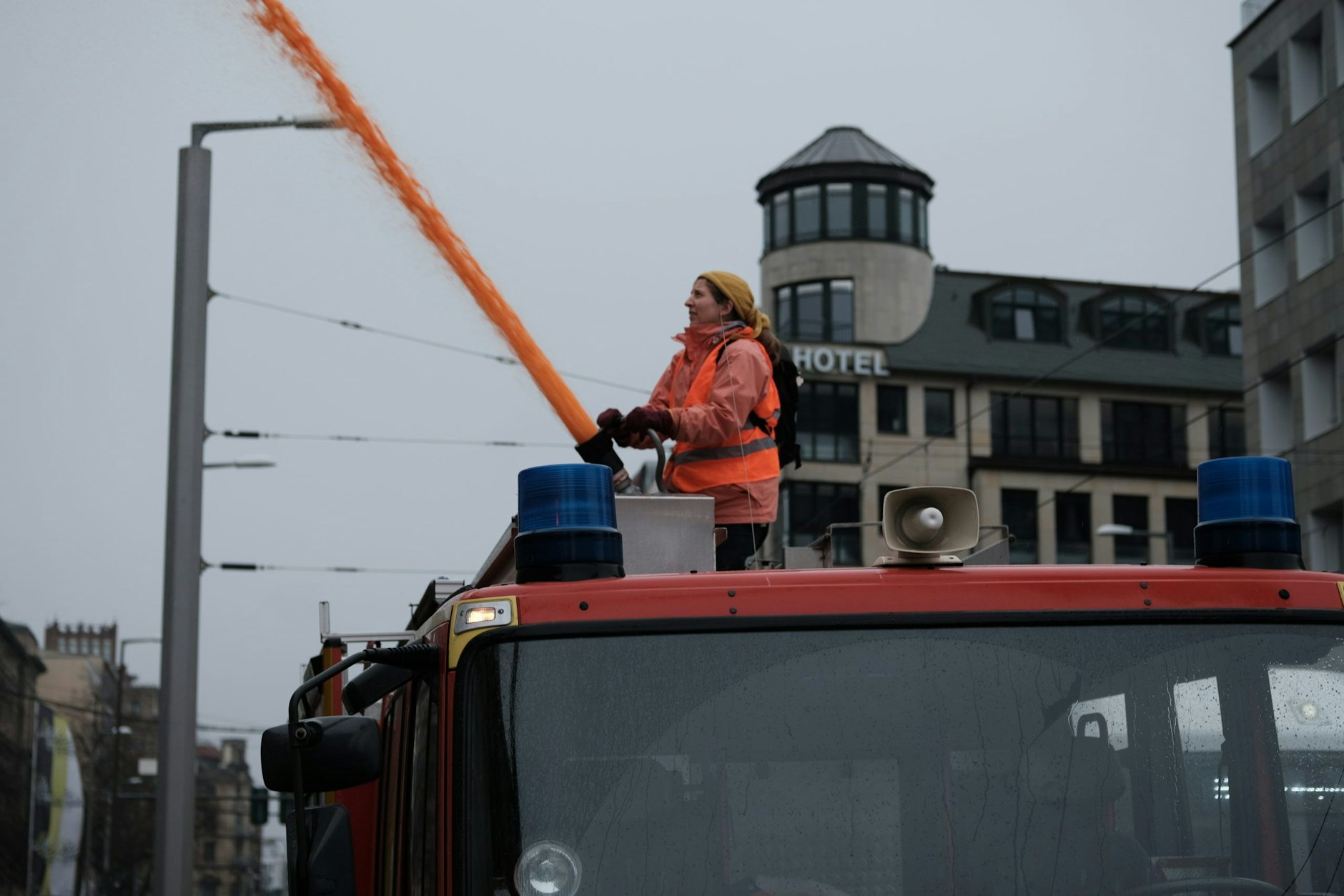 Eine Aktivistin sprüht vom Dach des Feuerwehrautos ein Wasserfarbgemisch auf das Verkehrsministerium in Berlin. Die Aktion hat jetzt ein Nachspiel.