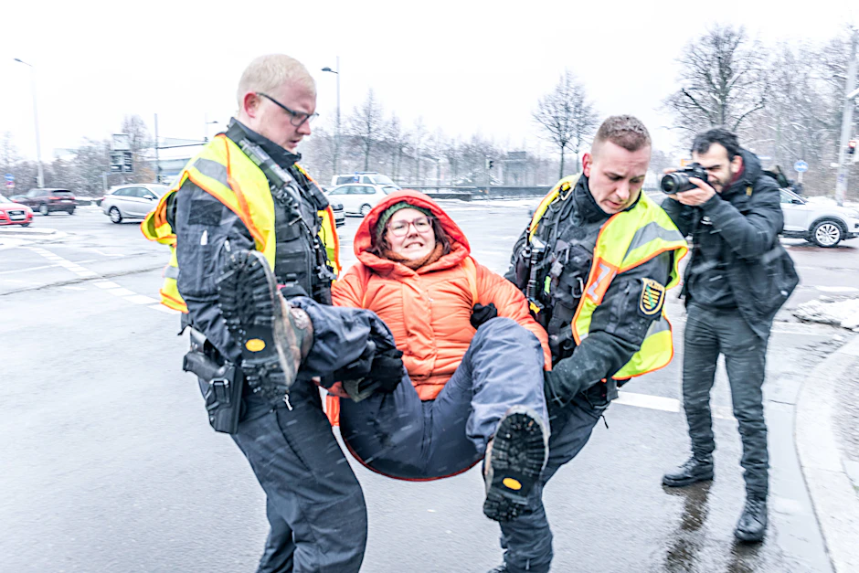 Ein Klimaaktivistin der Letzten Generation wird von der Polizei weggetragen.