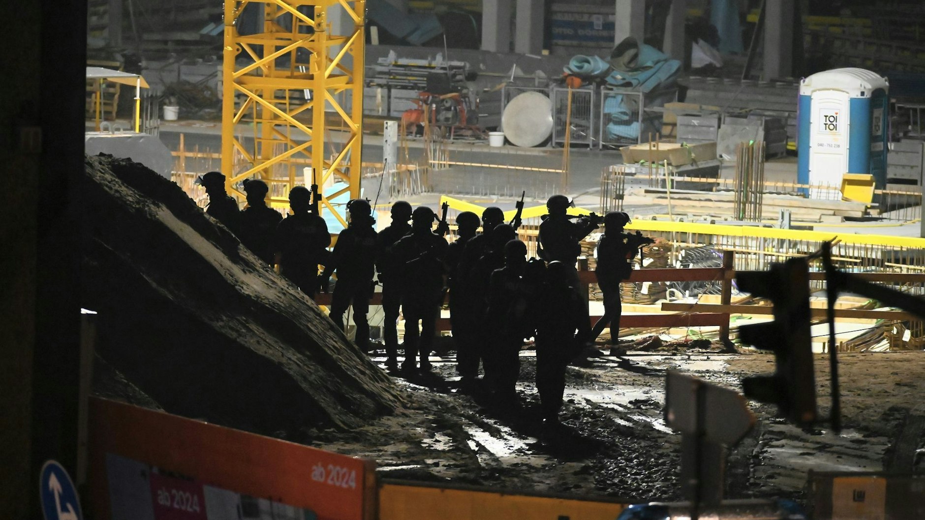 Polizisten in Spezialausrüstung stehen neben einem Gebäude der Zeugen Jehovas in Hamburg. Augenzeugen dachten zunächst, der Lärm käme von der angrenzenden Baustelle.