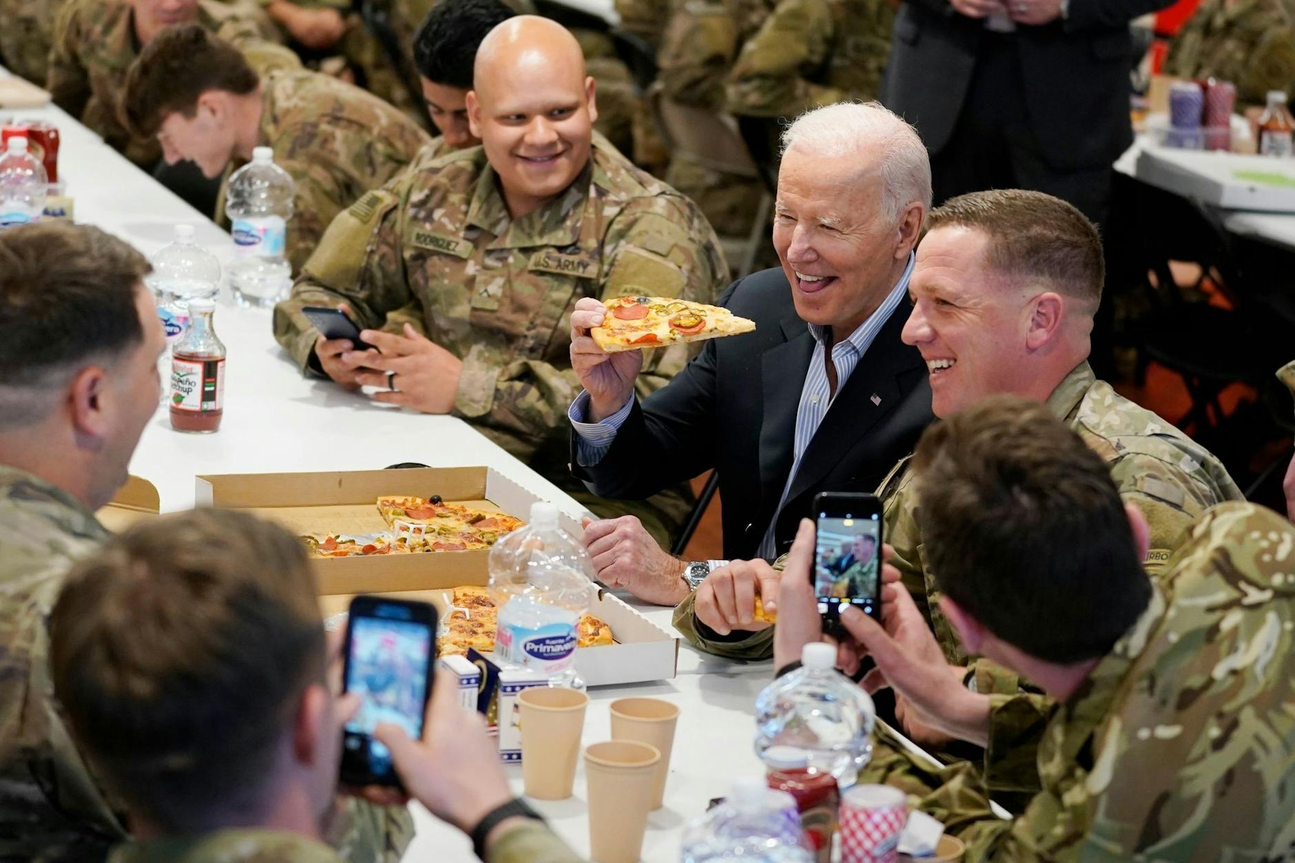 Auch ein Präsident hat mal Hunger: Joe Biden isst ein Stück Pizza, während er in der G2A Arena Angehörige der 82. Luftlandedivision der U.S. Army 2022 in Rzeszów trifft.