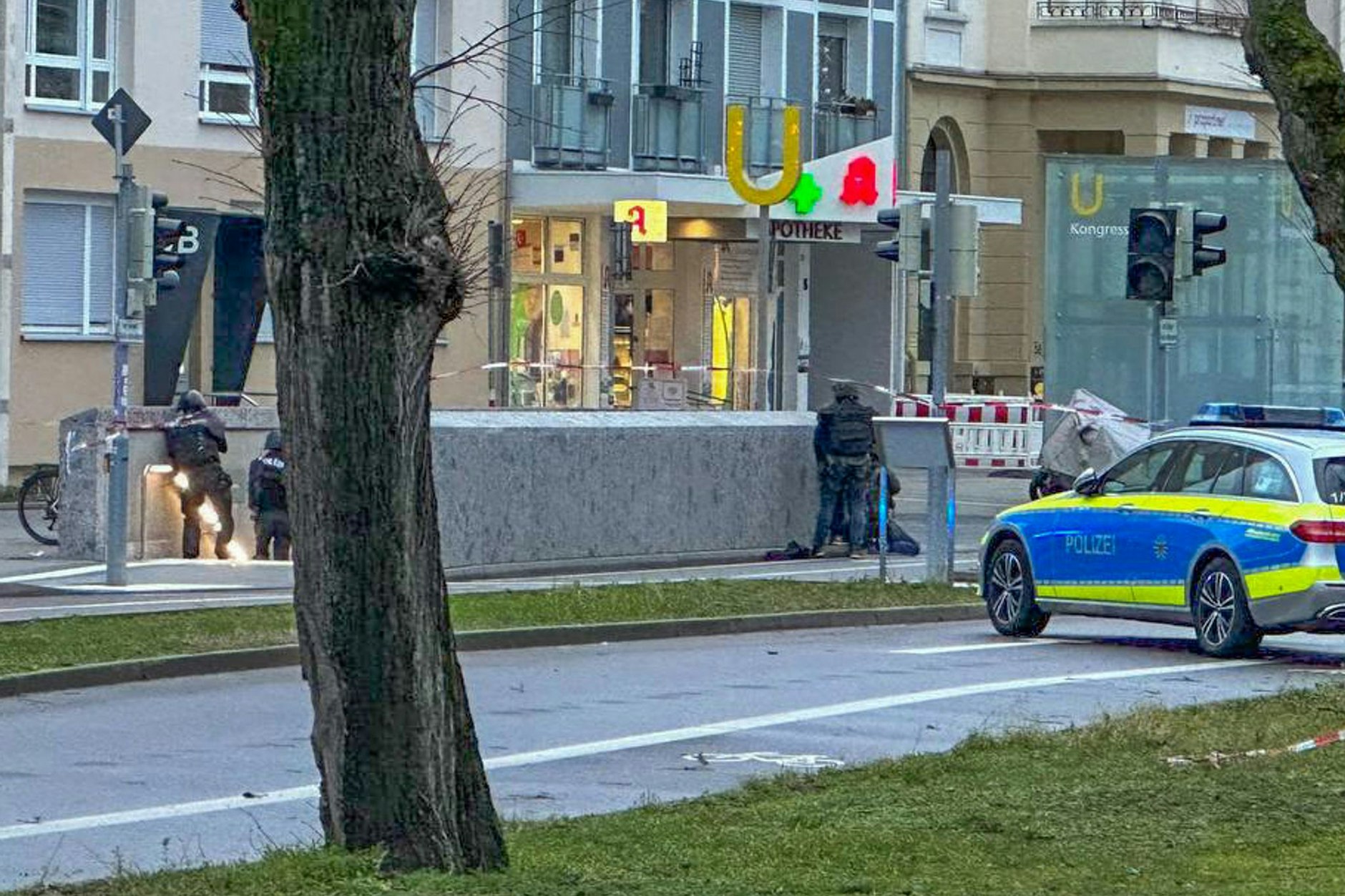 Polizisten stehen in Spezialausrüstung vor der Apotheke. 
