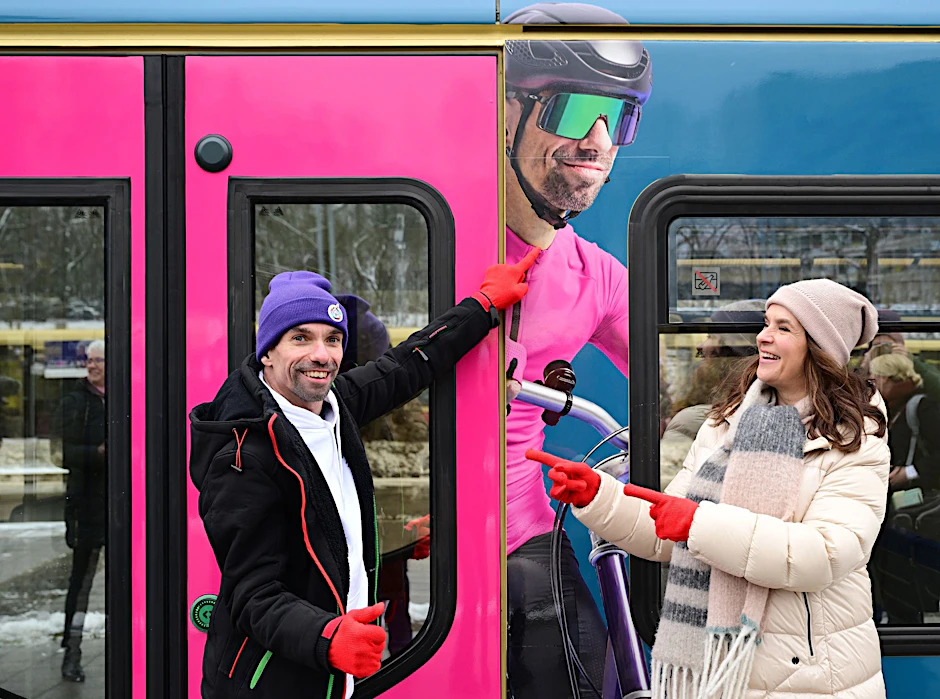 Ex-Eiskunstläuferin Katarina Witt (r) und Radsportler Robert Herberg stehen im Bahnhof Olympiastadion vor einem S-Bahnzug mit einem Foto von Herberg.  