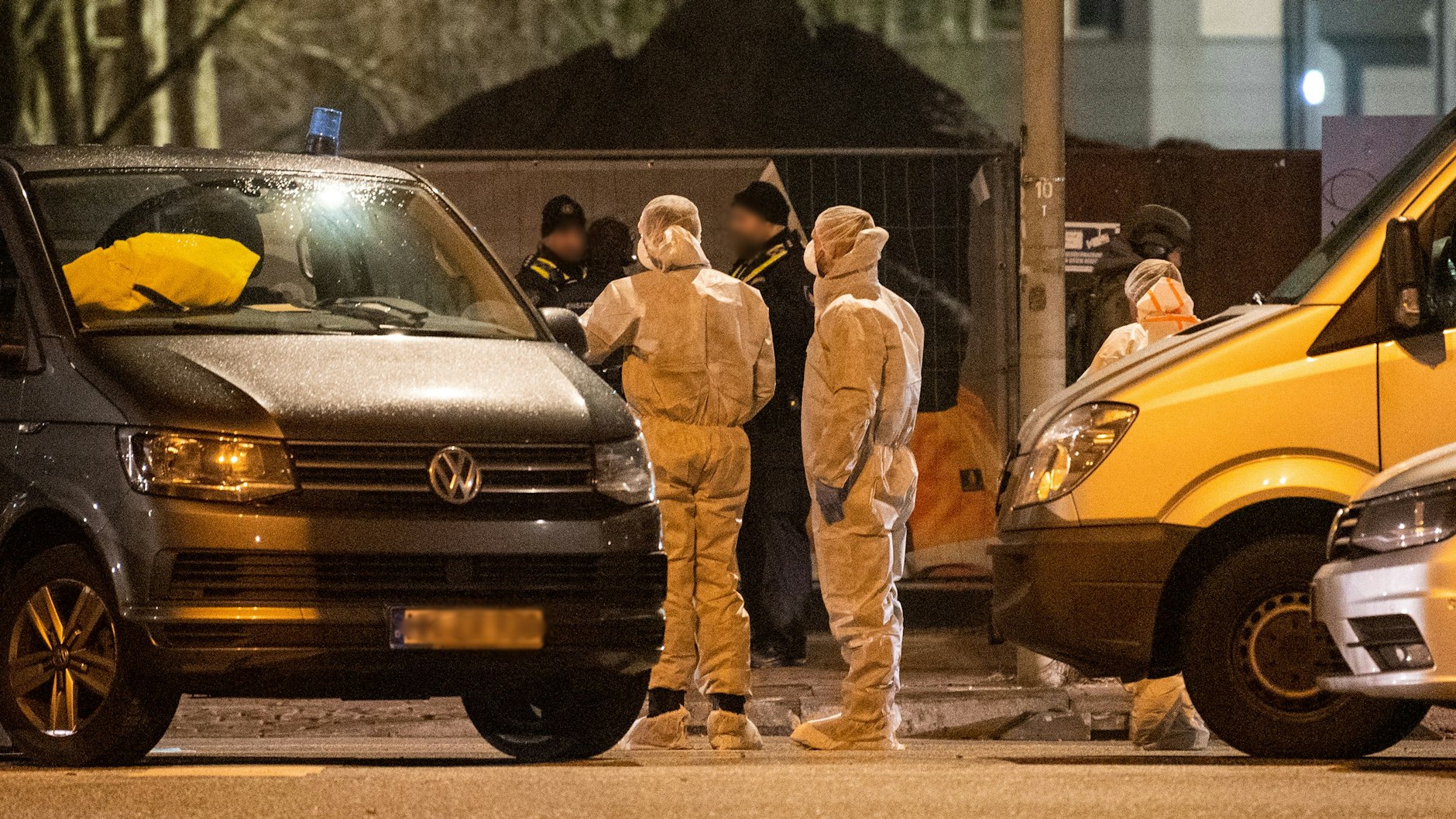 Mitarbeiter der Spurensicherung stehen vor einem Gebäude der Zeugen Jehovas. 