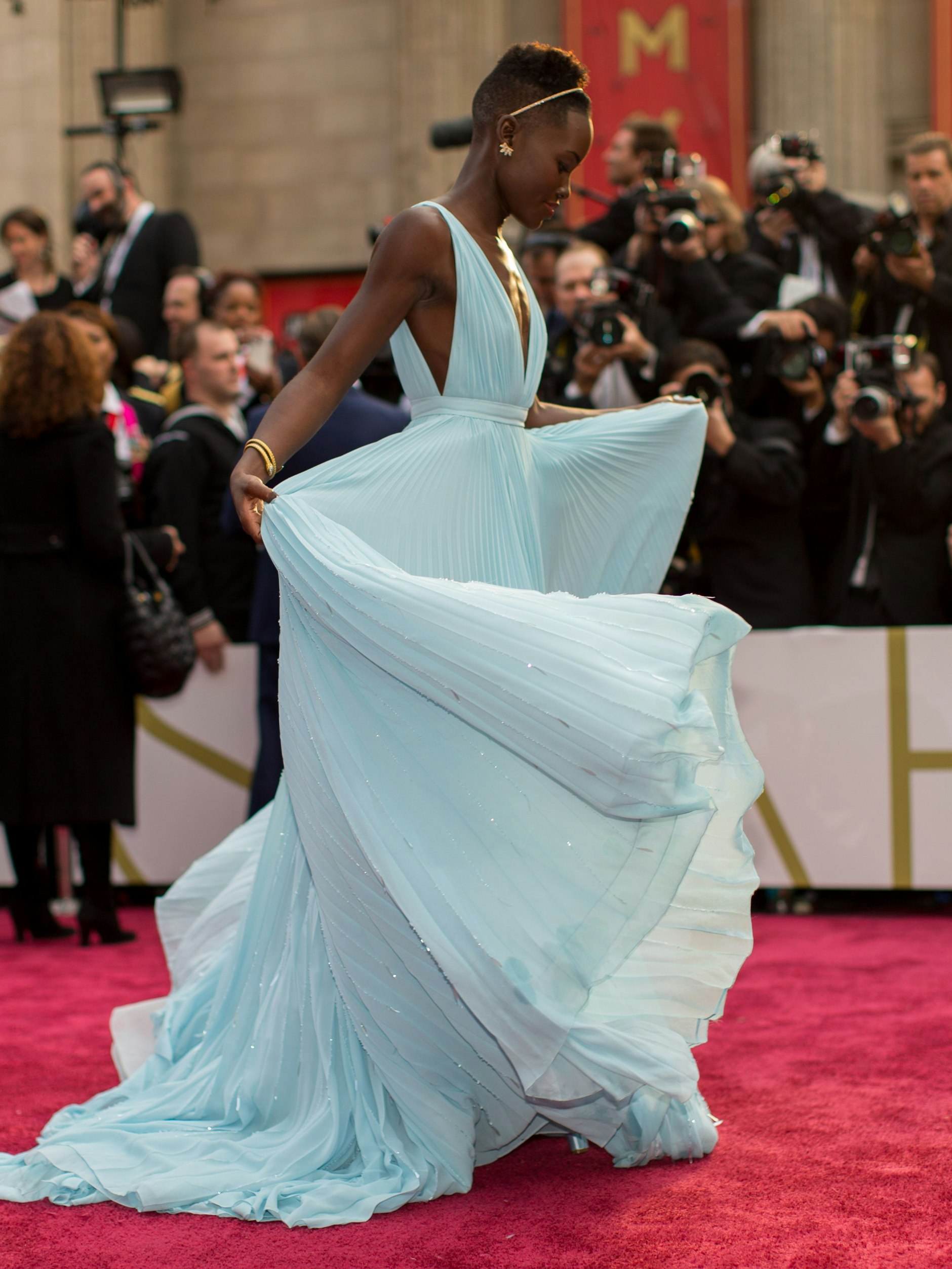 2014: Lupita Nyong’o im Göttinnenkleid von Prada, sie erhielt den Oscar als Beste Nebendarstellerin für „12 Years a Slave“. Ihr diamantbesetzter Haarreif wurde sofort mit Strasssteinen massenkopiert.