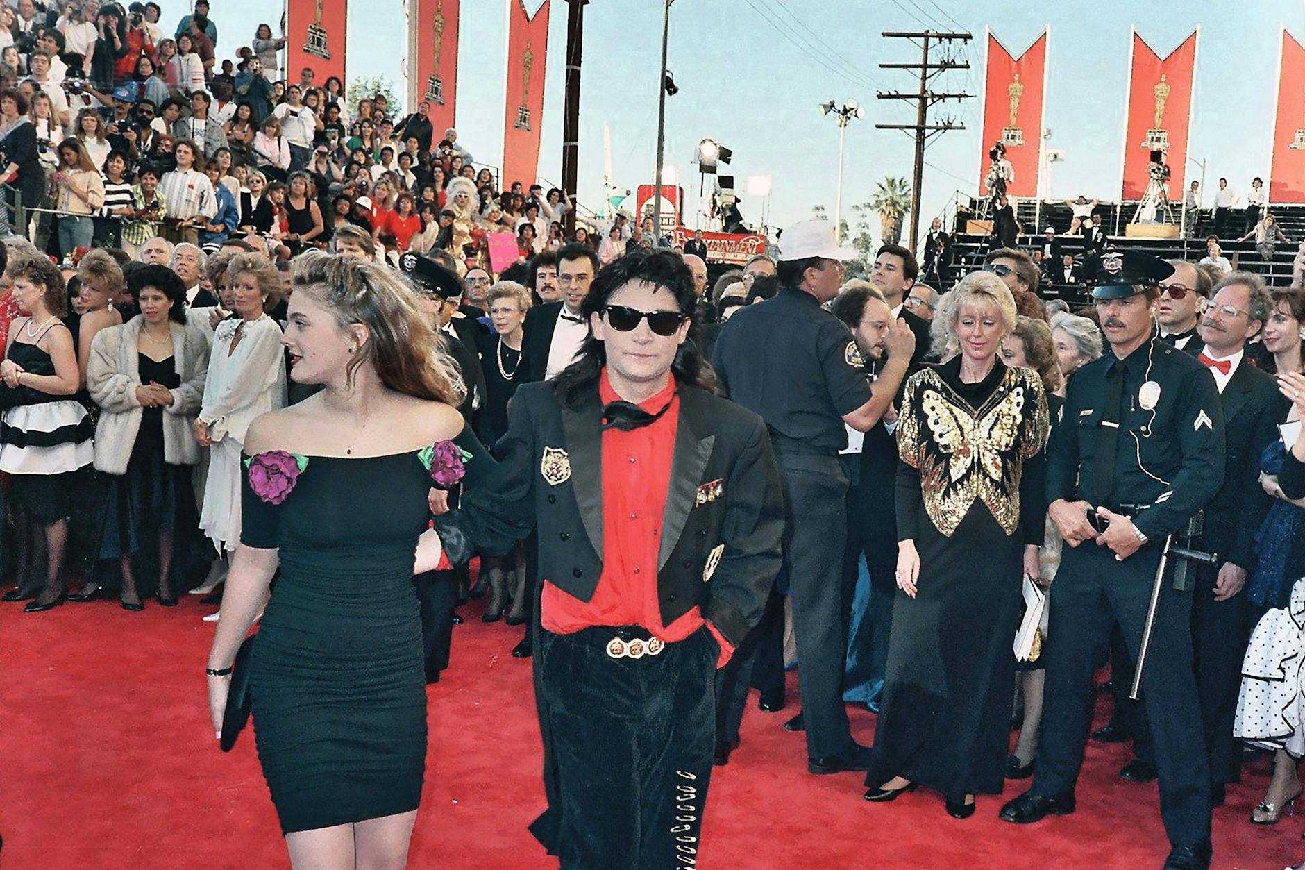 1989: „Bad Girl“ Drew Barrymore, im Schlauchkleid von Betsey Johnson, und „Bad Boy“ Corey Feldman im Vampirlook. Man sieht: Auch die Nicht-Stars kleideten sich immer individueller für die Oscars.