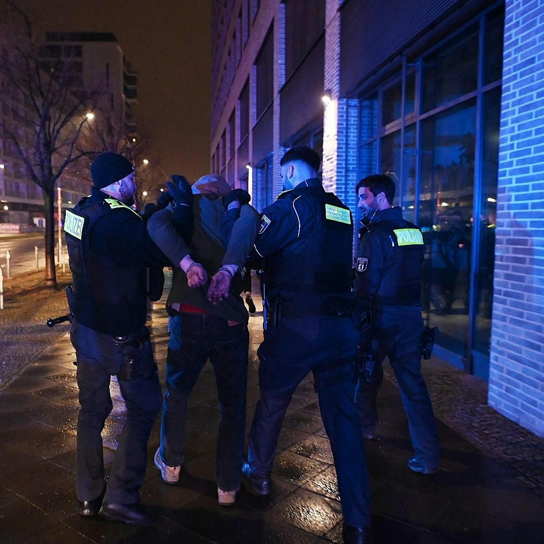 Auf frischer Tat ertappt: Die Berliner Polizei legt zwei Feuerteufel in Handschellen, die gerade Fußmatten in einem Wohnhaus angezündet hatten