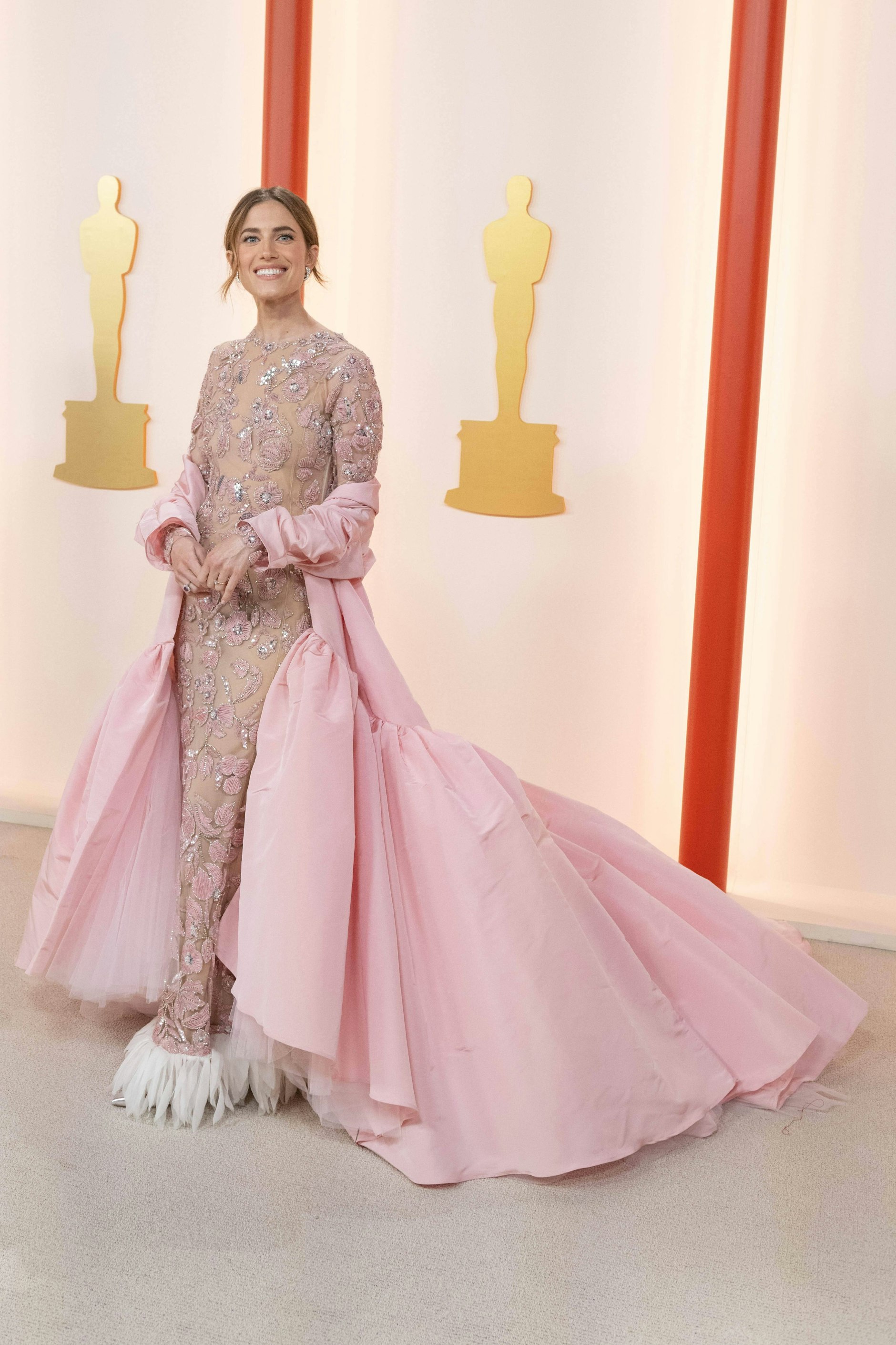 <strong>Flop:</strong> Die Farbe steht Allison Williams wirklich ausgezeichnet. Das wars dann aber schon, was es an lobenden Worten für diese Robe geben kann. Sie wirkt einfach unentschieden, wartet mit viel zu vielen Schmuckelementen und Details auf: dem mantelartigen Überwurf samt Schleppe, den Tüllpartien darunter, dem Blumenmuster aus Pailletten und Schmucksteinen, dem Federsaum – nächstes Mal bitte einen Gang zurückschalten!