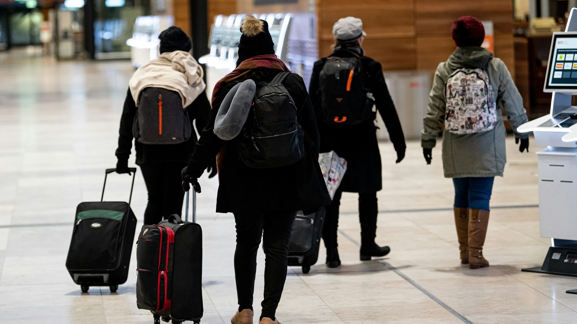 Gestrandete Fluggäste, die vom Streik nichts mitbekommen hatten, gehen am Montag durch die Abfertigungshalle am BER-Flughafen.