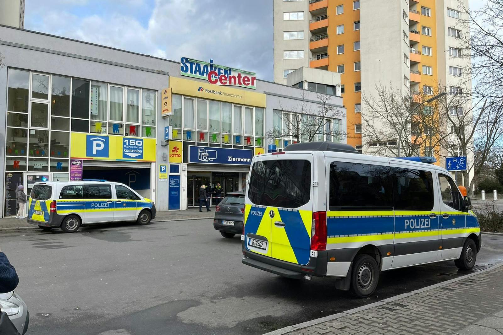 Einsatzwagen der Polizei stehen nach dem Messerangriff vor dem Staaken-Center. 