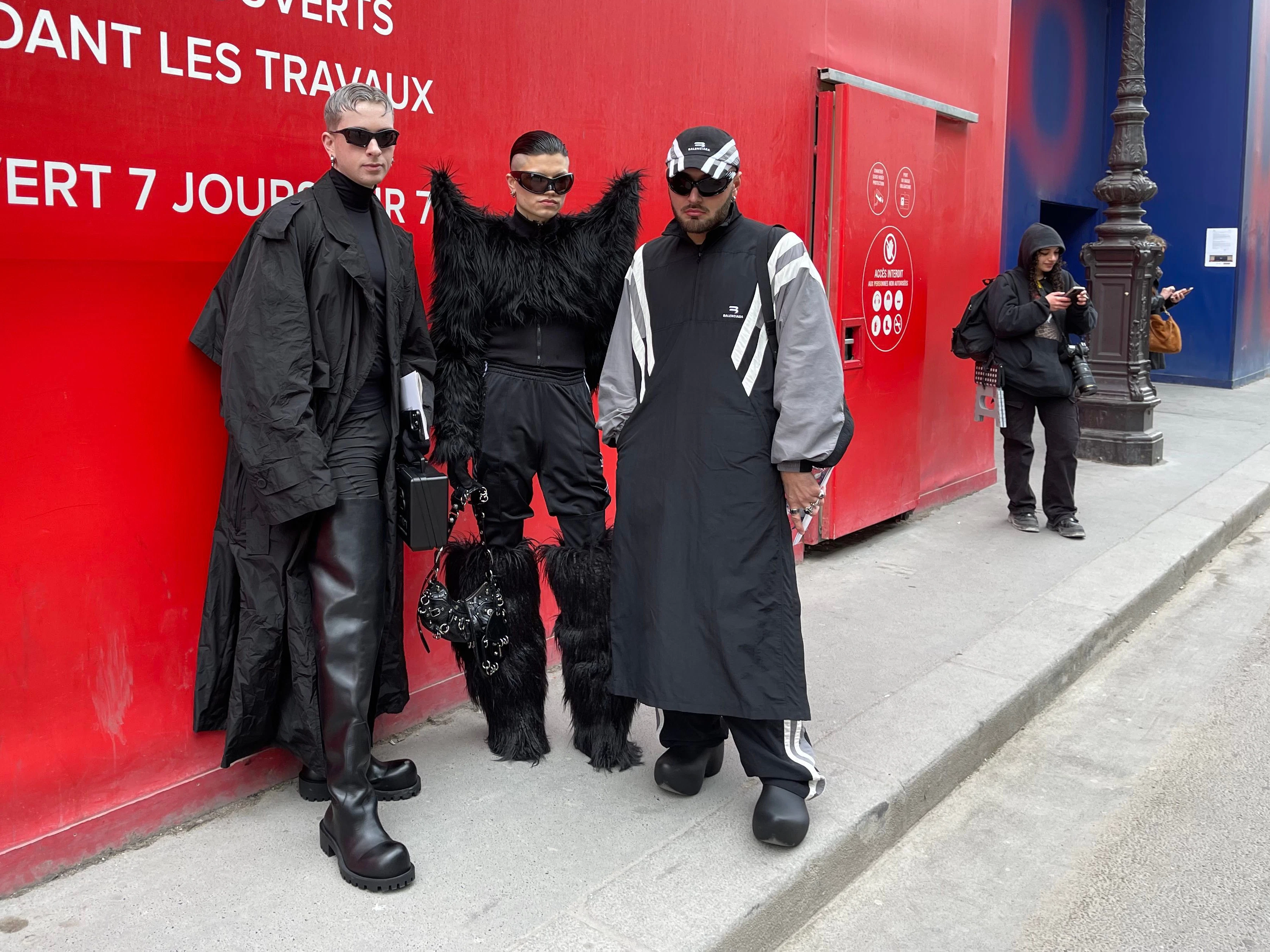 Schwarzer Balenciaga-Futurismus: Drei Gäste warten vor dem Pariser Carrousel du Louvre auf den Beginn der Show.