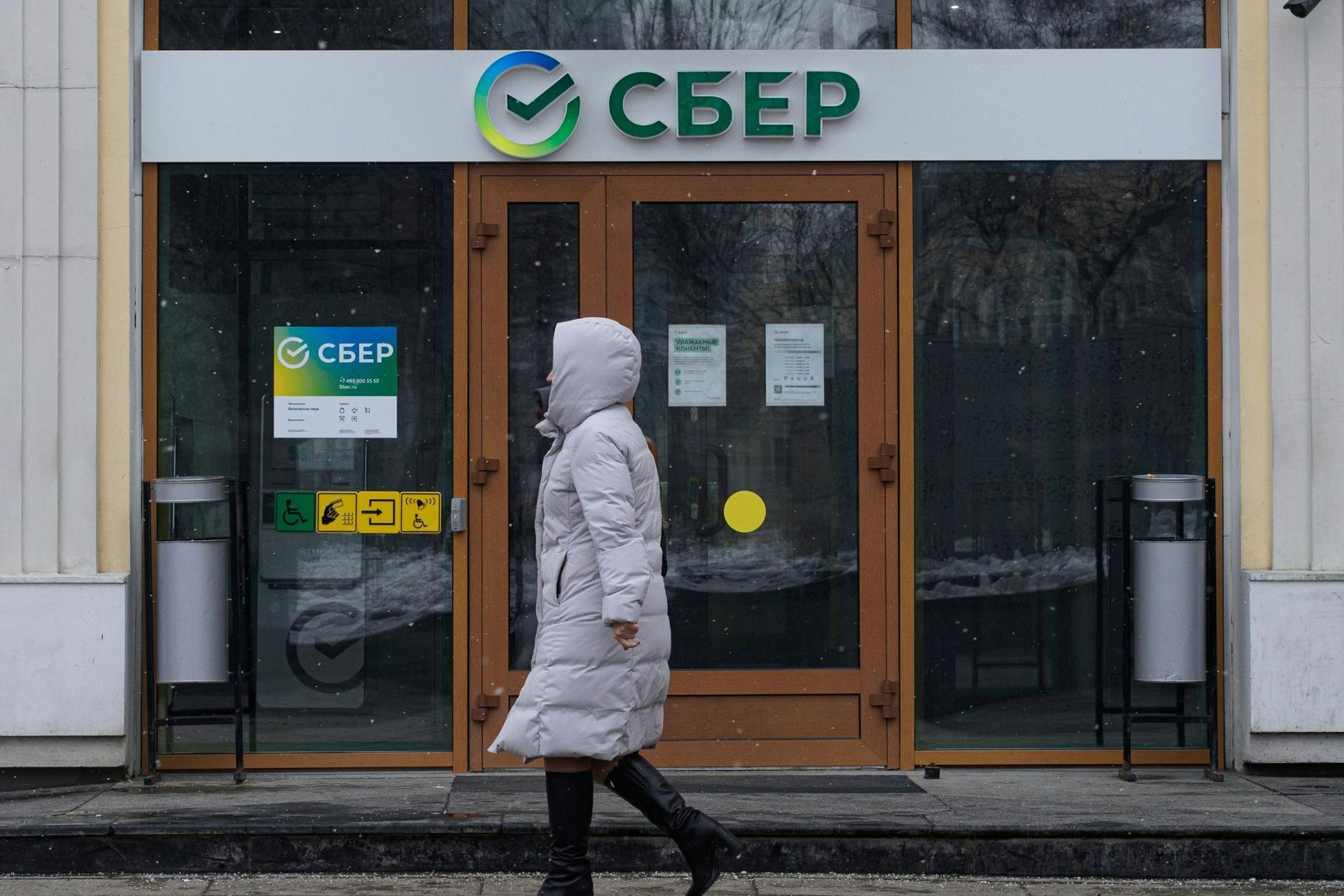 Eine Bankkundin vor dem Gebäude einer Filiale von Sberbank. Die größte russische Bank ist seit dem 4. Mai 2023 auf der Sanktionsliste der EU.