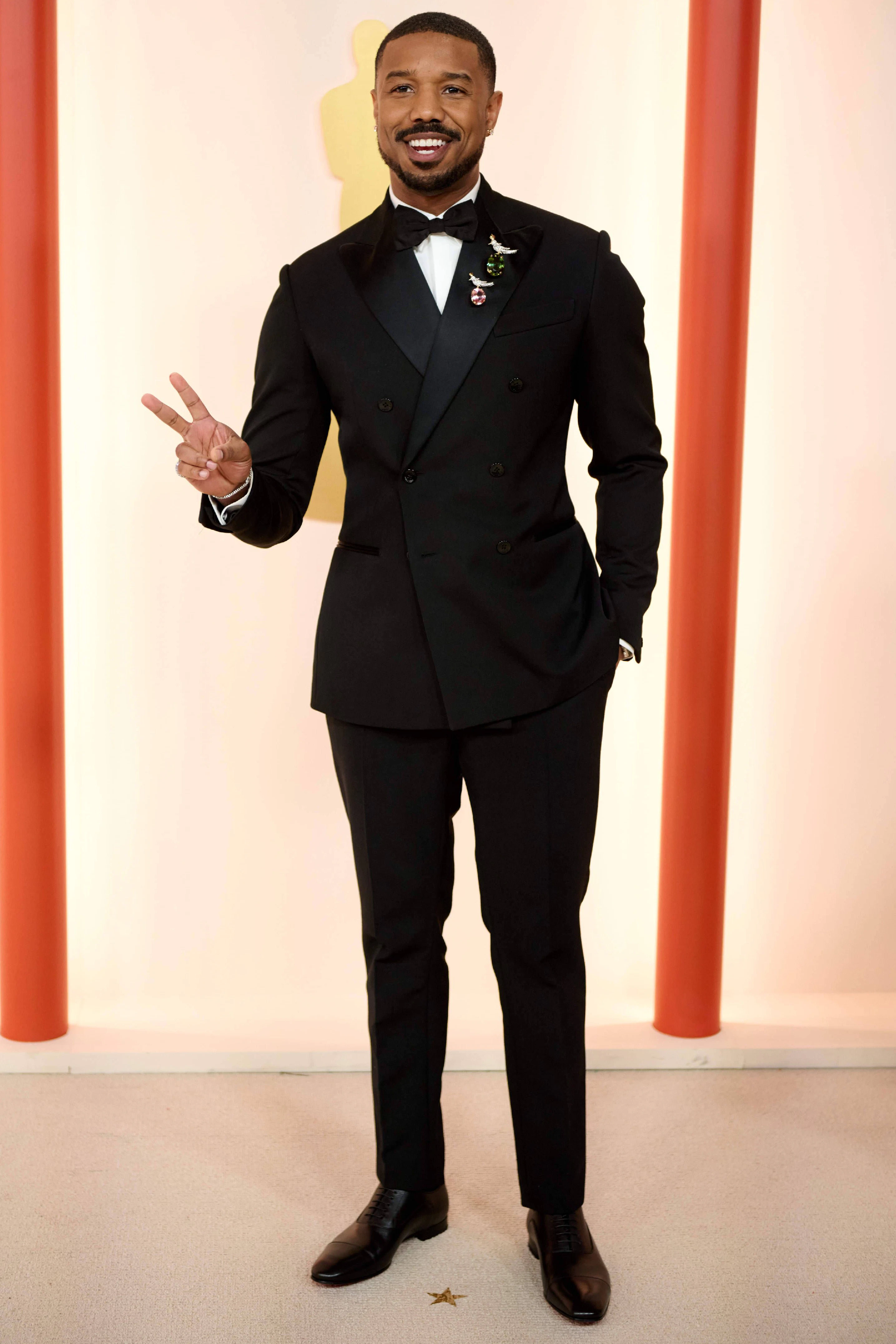 <strong>Top:</strong> Ja, der Louis-Vuitton-Anzug sitzt perfekt, sieht gut aus, ist ganz wunderbar. Die wahren Stars dieses Looks aber sind die kleinen Anstecker von Tiffany’s, mit denen Michael B. Jordan seinem recht klassischen Auftritt einen kleinen Twist verleiht. Die Pins in Form von diamantbesetzten Vögelchen strahlen mit dem Schauspieler um die Wette und zeigen: Auch im kleinsten Detail kann eine große modische Stärke liegen.