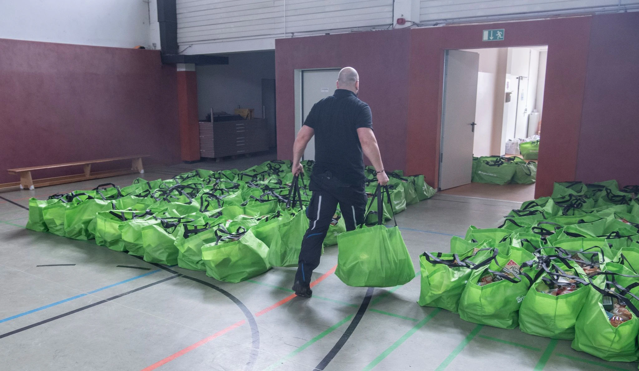 ARCHIV - Unterstützung für Bedürftige: Ein Mann bereitet die Tüten mit Lebensmittel für die Ausgabe in der Arche in Berlin-Hellersdorf vor.  