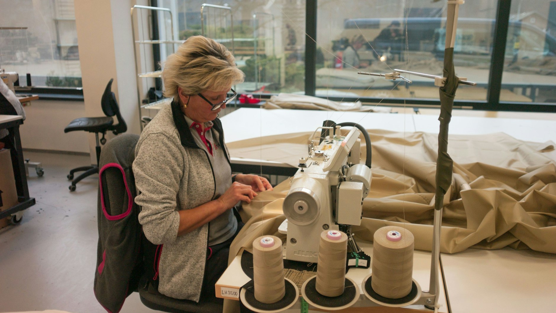 Eine Mitarbeiterin näht für aufblasbare Attrappen von schweren Militärfahrzeugen Stoff zusammen. 