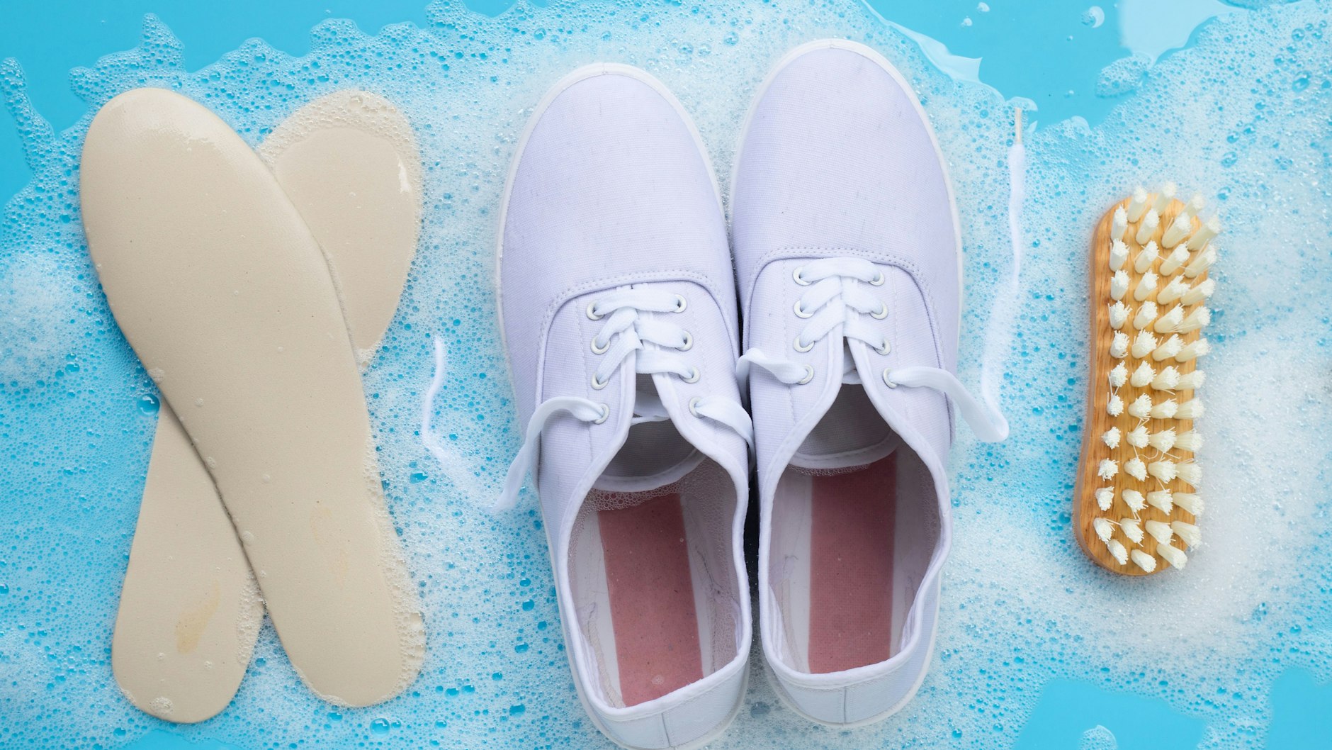 Bevor die Turnschuhe aus Stoff in der Waschmaschine wieder schön weiß gewaschen werden, groben Schmutz mit der Bürste entfernen und Einlegesohlen rausnehmen. 