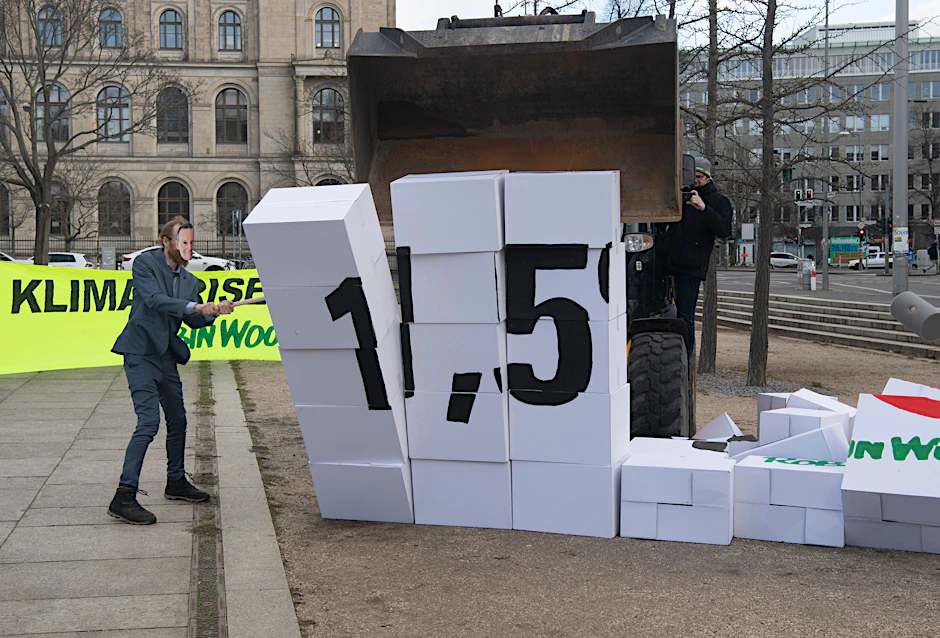 Aktivisten der Umweltschutz-Gruppe Robin Wood reißen bei einer Protestaktion am Bundesverkehrsministerium eine Mauer aus Kartons mit einem Bagger um.
