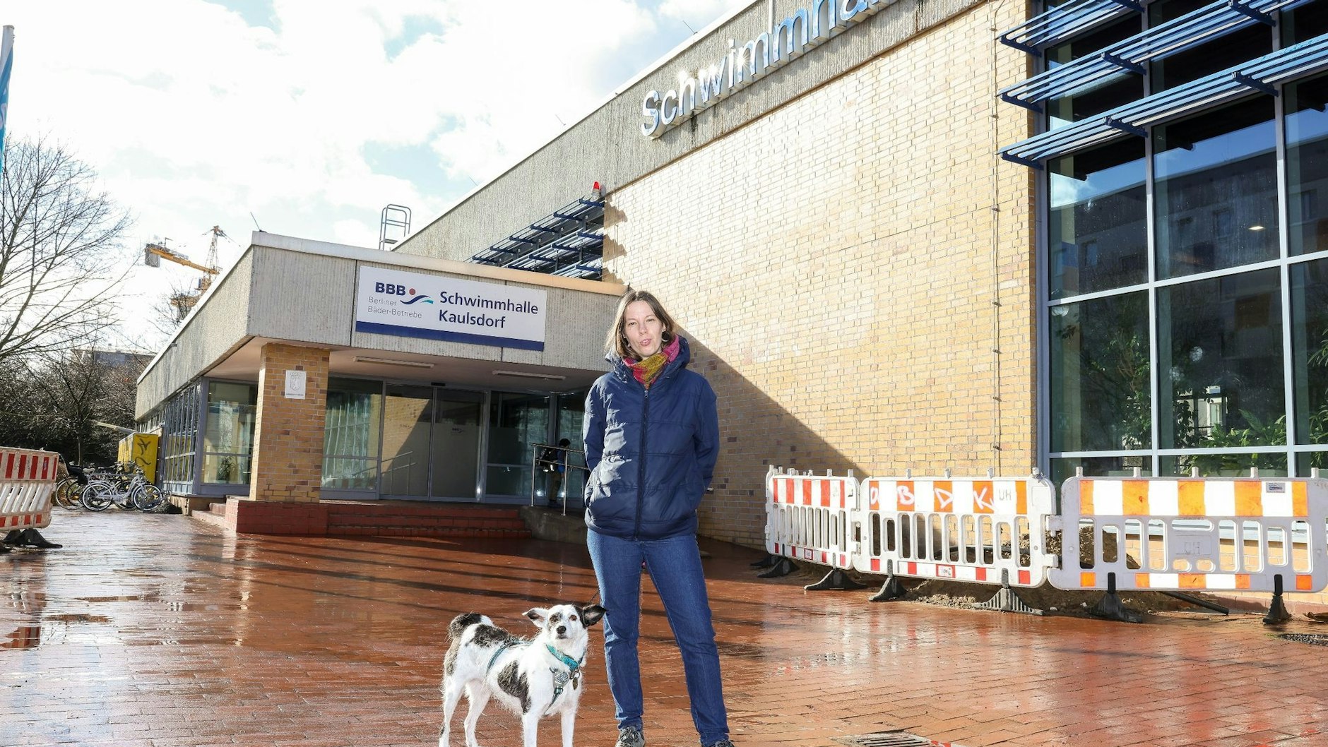 Lotte Mies steht mit ihrem Hund vor der Schwimmhalle Kaulsdorf. 