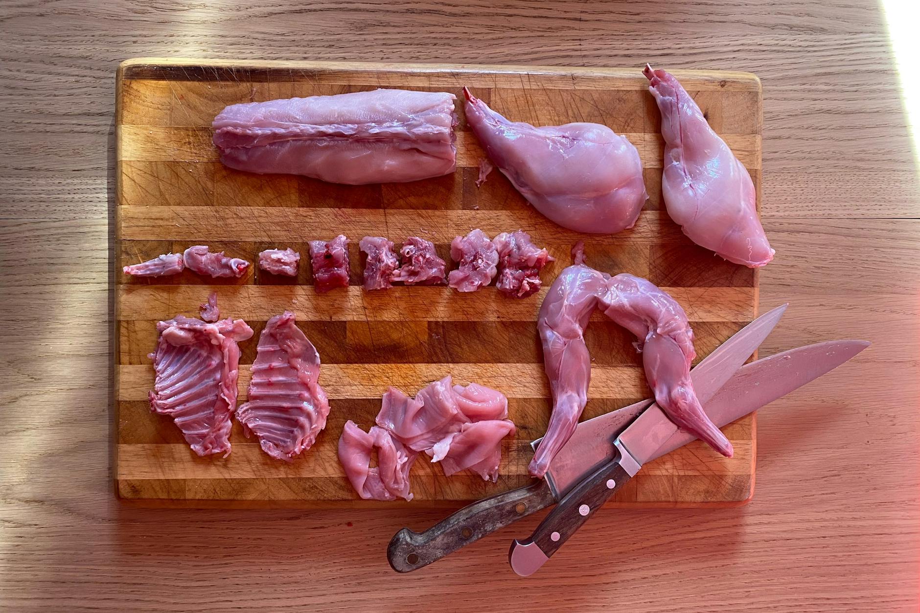 Kaninchen zerlegt in seine Einzelteile: Schlegel und Keulen werden mit den anderen Teilen geschmort, der Rücken wird gebraten.