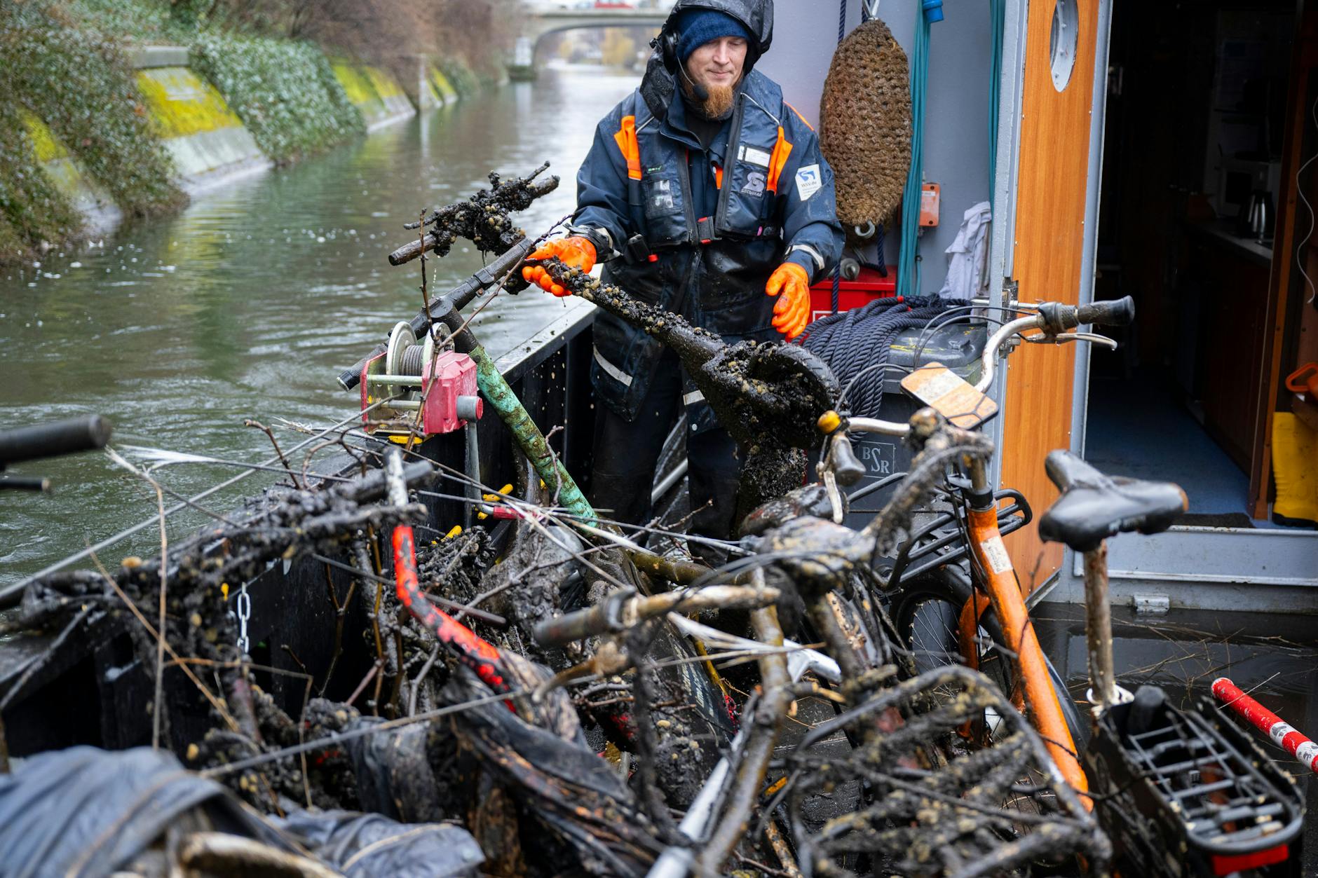 Stephan Strauch, Mitarbeiter vom Wasser- und Schifffahrtsamt, zieht bei einer Schiffsfahrt zur Hindernisbergung im Landwehrkanal einen E-Roller aus dem Wasser. 