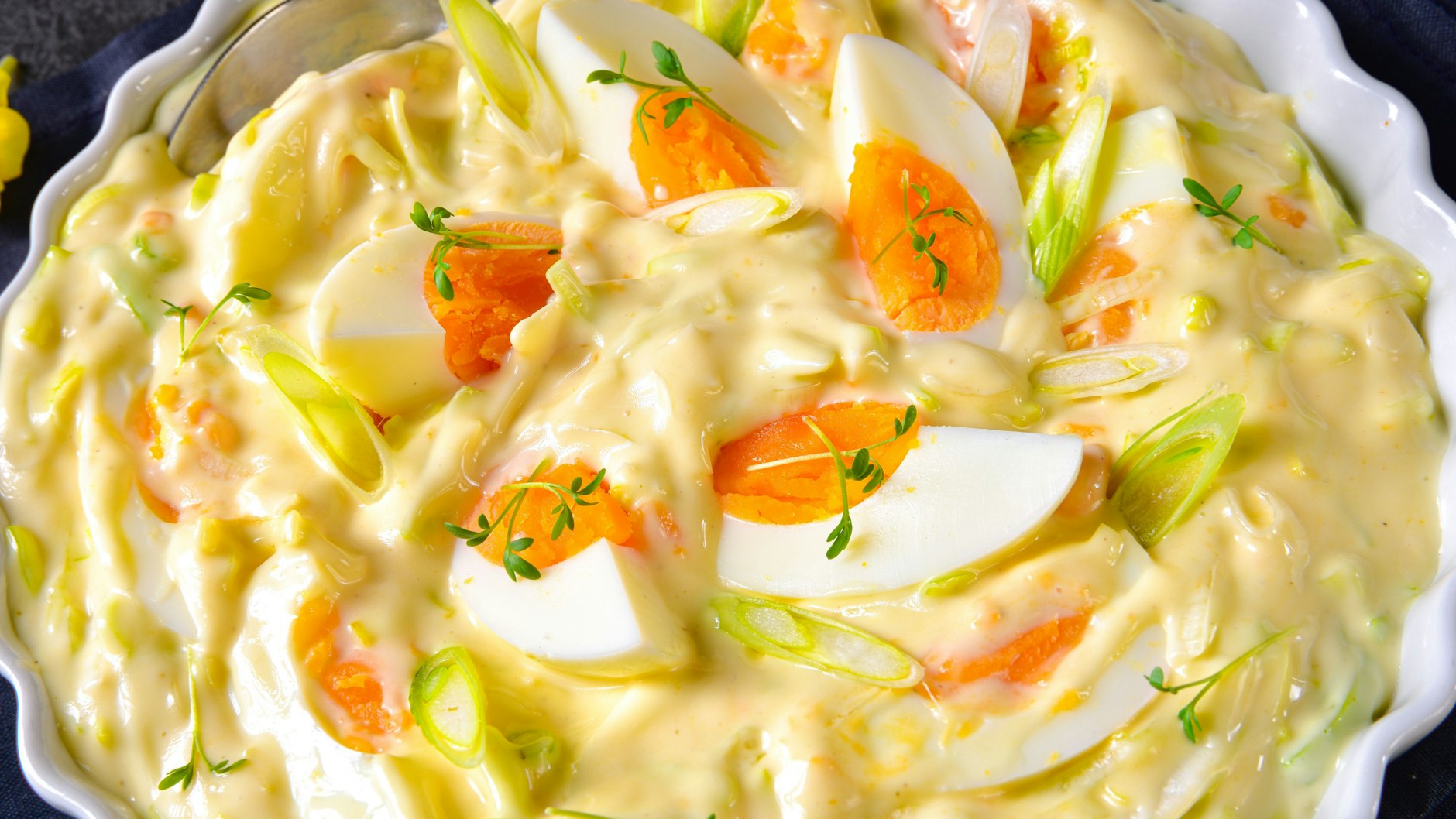 Der 7-Tassen-Salat kann mit Eiern und Kräutern verziert werden - so ist er der Hingucker auf dem Esstisch. Probieren Sie das Rezept unbedingt aus!