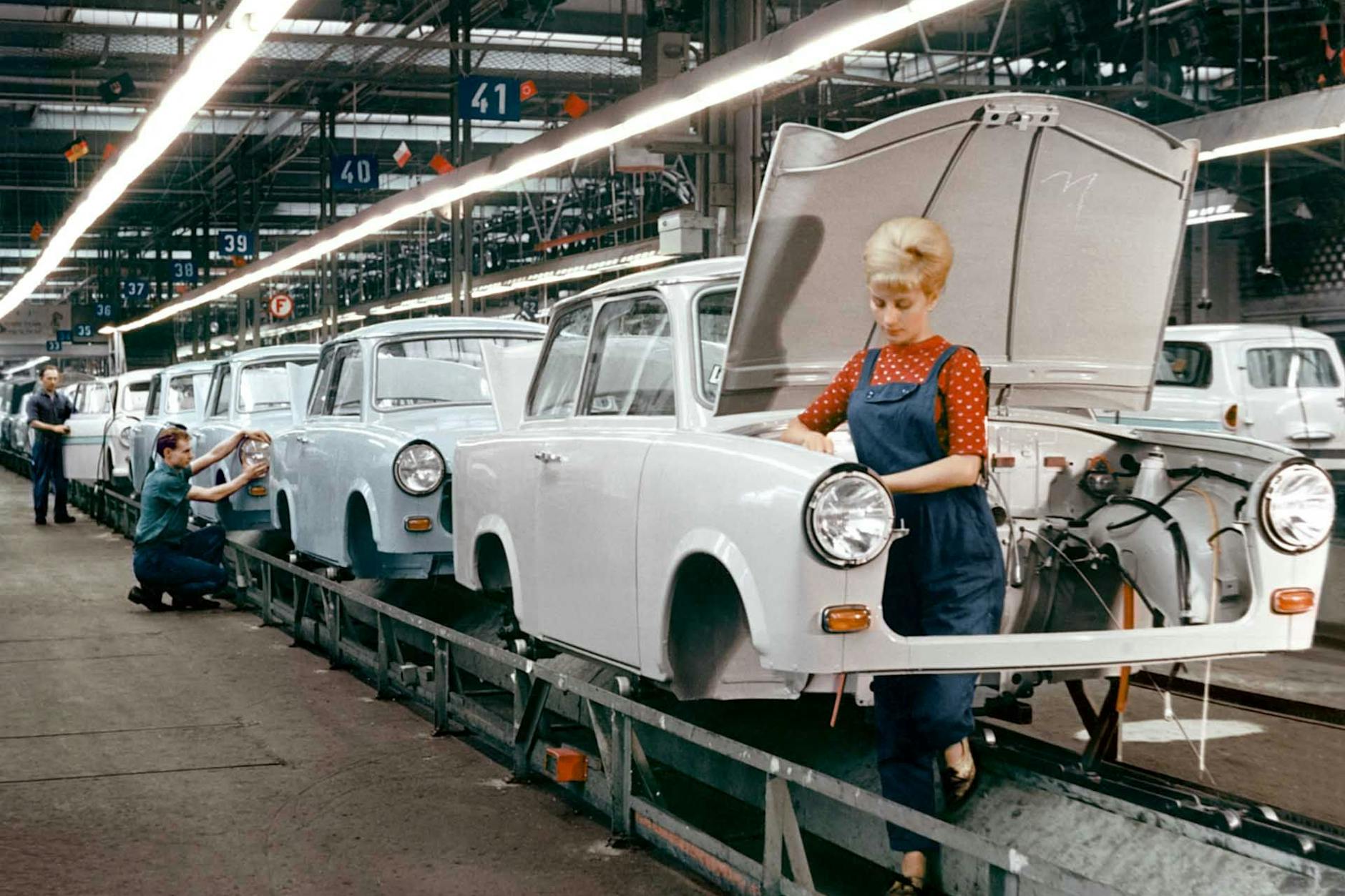 Hier ist alles inszeniert: Arbeiterin an der Montagestraße des Trabant P60 im VEB Automobilbau Zwickau um 1962. Die modische Turmfrisur sitzt, der Blaumann ist tiptop gebügelt. Aber in der Montage des bis 1964 produzierten P60 waren tatsächlich viele Frauen beschäftigt. 