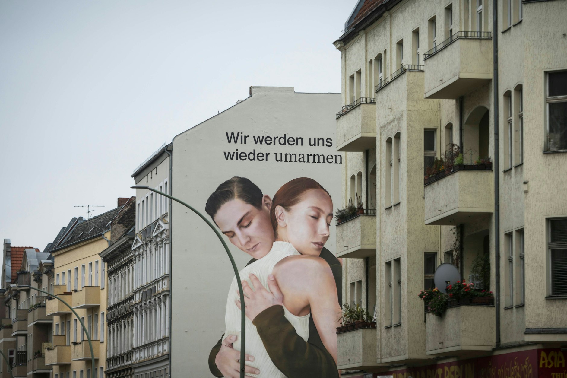 Ein Werbebild von Zalando mit zwei sich umarmenden Menschen in Berlin Neukölln.