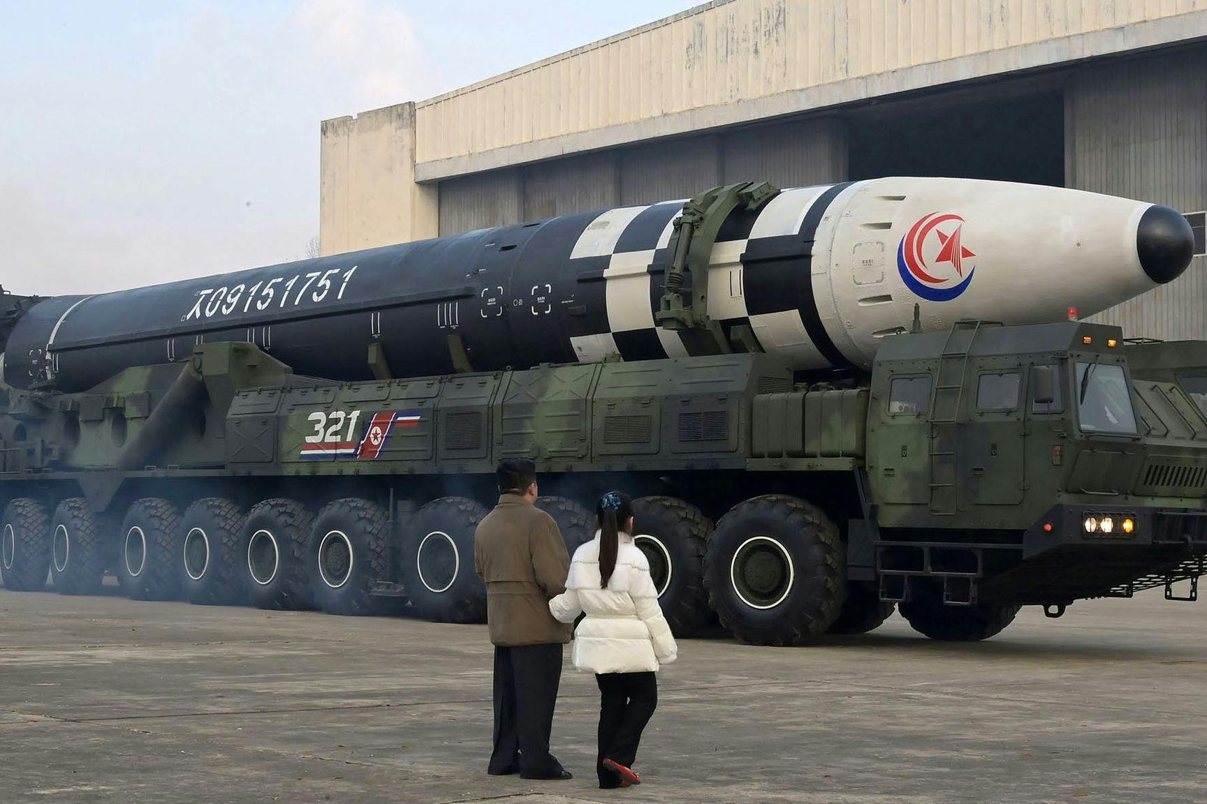 Kim Jong-un geht nach nordkoreanischen Angaben in Begleitung seiner Tochter vor einem Militärfahrzeug mit einer Rakete entlang.