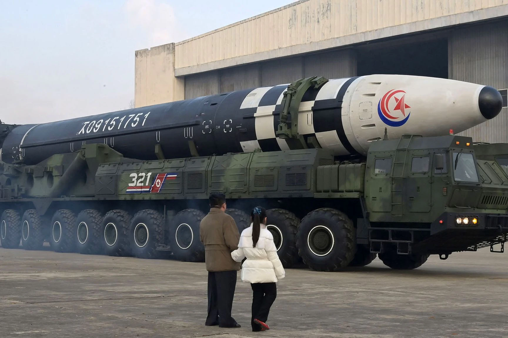 Kim Jong-un geht nach nordkoreanischen Angaben in Begleitung seiner Tochter vor einem Militärfahrzeug mit einer Rakete entlang.