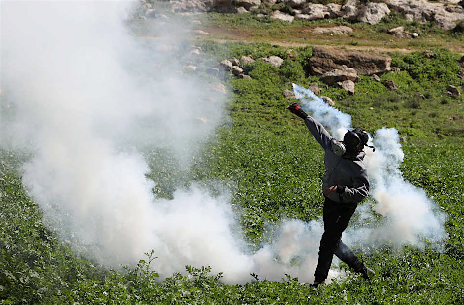 Ein Palästinenser wirft eine Rauchbombe auf israelische Soldaten. Seit Wochen kommt es in der Region um Nablus zu gewaltsamen Auseinandersetzungen.&nbsp;