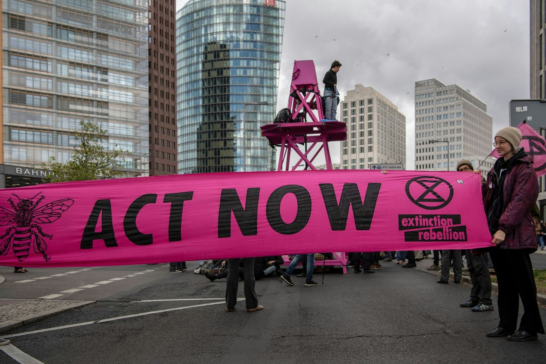 „Act now“ steht auf einem Transparent der Umweltschutzgruppe Extinction Rebellion bei einer Straßenblockade am Potsdamer Platz.