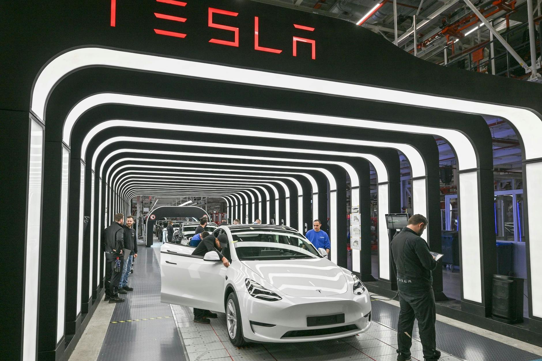 In der Gigafactory Grünheide: Mitarbeiter von Tesla führen die Endkontrolle fertiger Elektrofahrzeuge vom Typ Model Y durch.