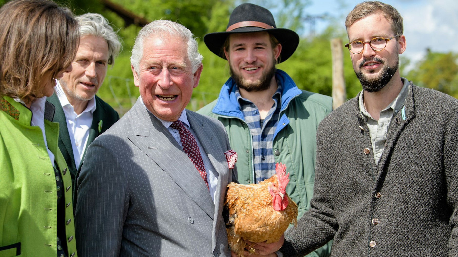 Charles, damaliger Prinz von Wales, hält bei dem Besuch des Bio-Bauernhofs Herrmannsdorfer Landwerkstätten einen Bruderhahn in den Händen.&nbsp;