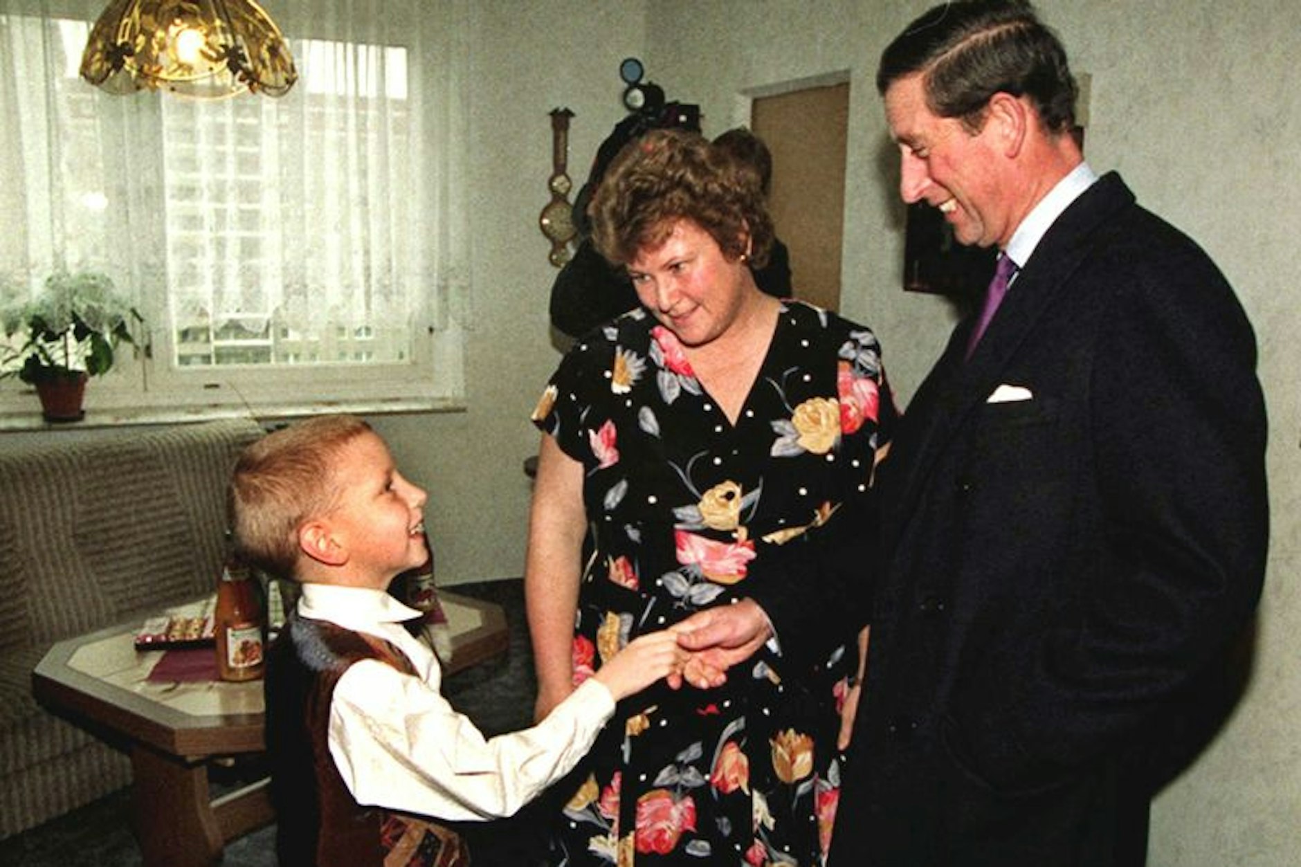 Prinz in der Platte: Neben Mutter Eva-Maria reicht der siebenjährige Christian Kunz dem damaligen britischen Thronfolger Prinz Charles zur Begrüßung in ihrer Wohnung in der Plattenbau-Siedlung die Hand im Jahr 1995.&nbsp;