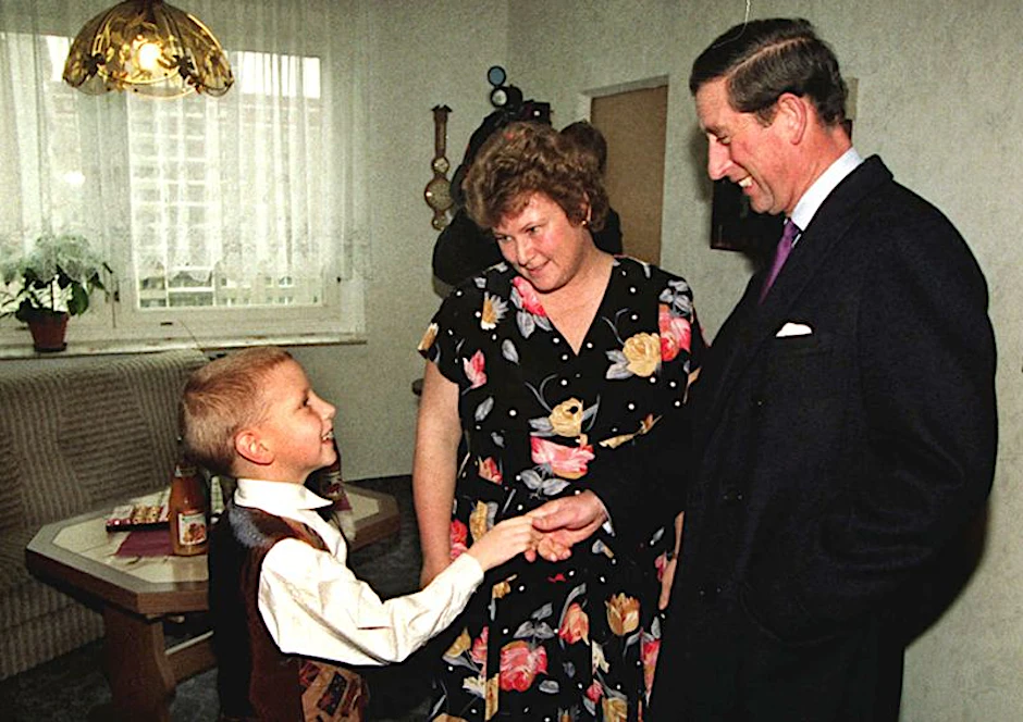 Prinz in der Platte: Neben Mutter Eva-Maria reicht der siebenjährige Christian Kunz dem damaligen britischen Thronfolger Prinz Charles zur Begrüßung in ihrer Wohnung in der Plattenbau-Siedlung die Hand im Jahr 1995.&nbsp;