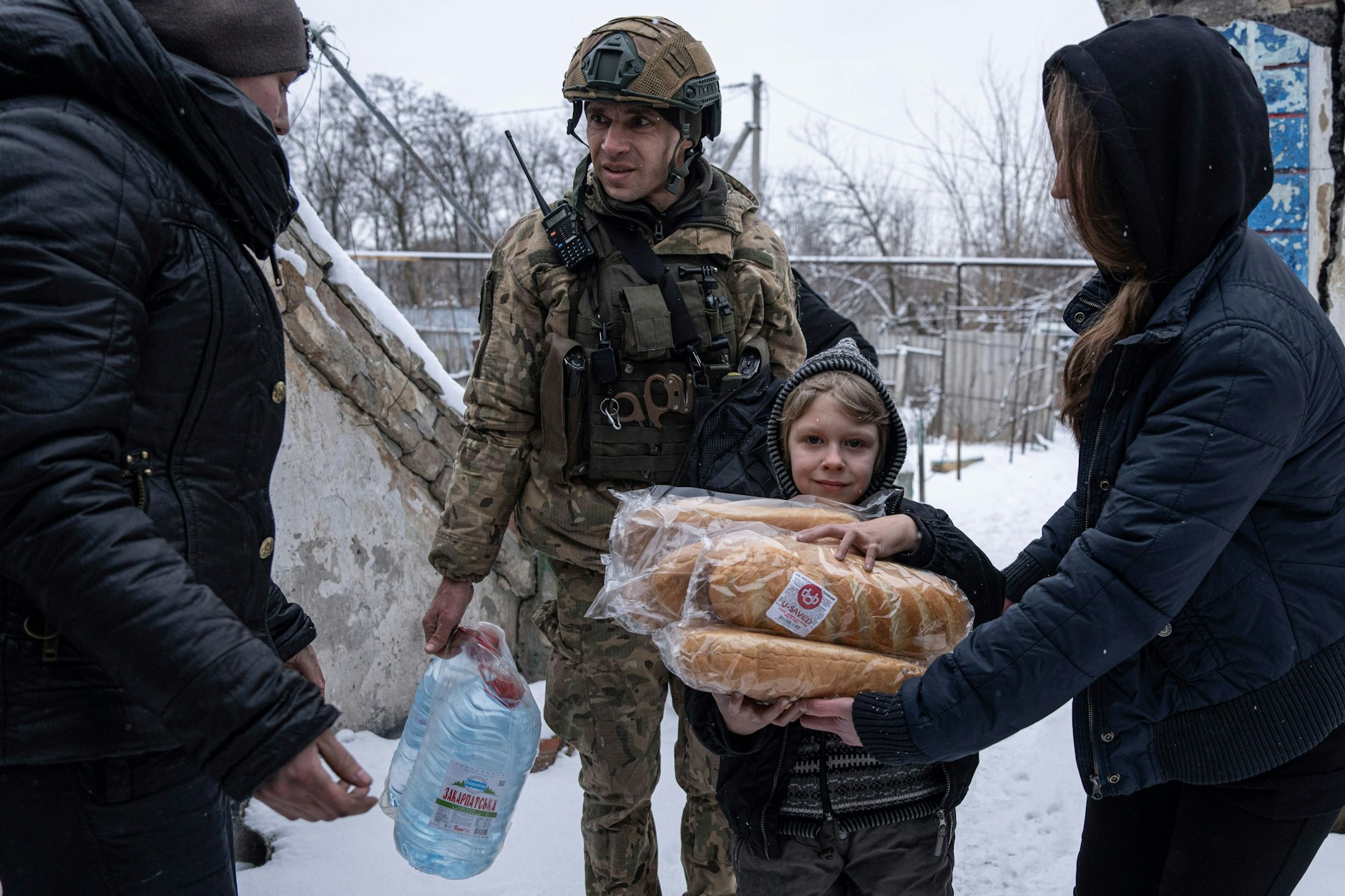 Ein ukrainischer Polizist der Weißen Engel verteilt Hilfsgüter&nbsp;an eine Familie. Die Spezialeinheit riskiert ihr Leben, um in Dörfer und Städte an der Front zu gehen.