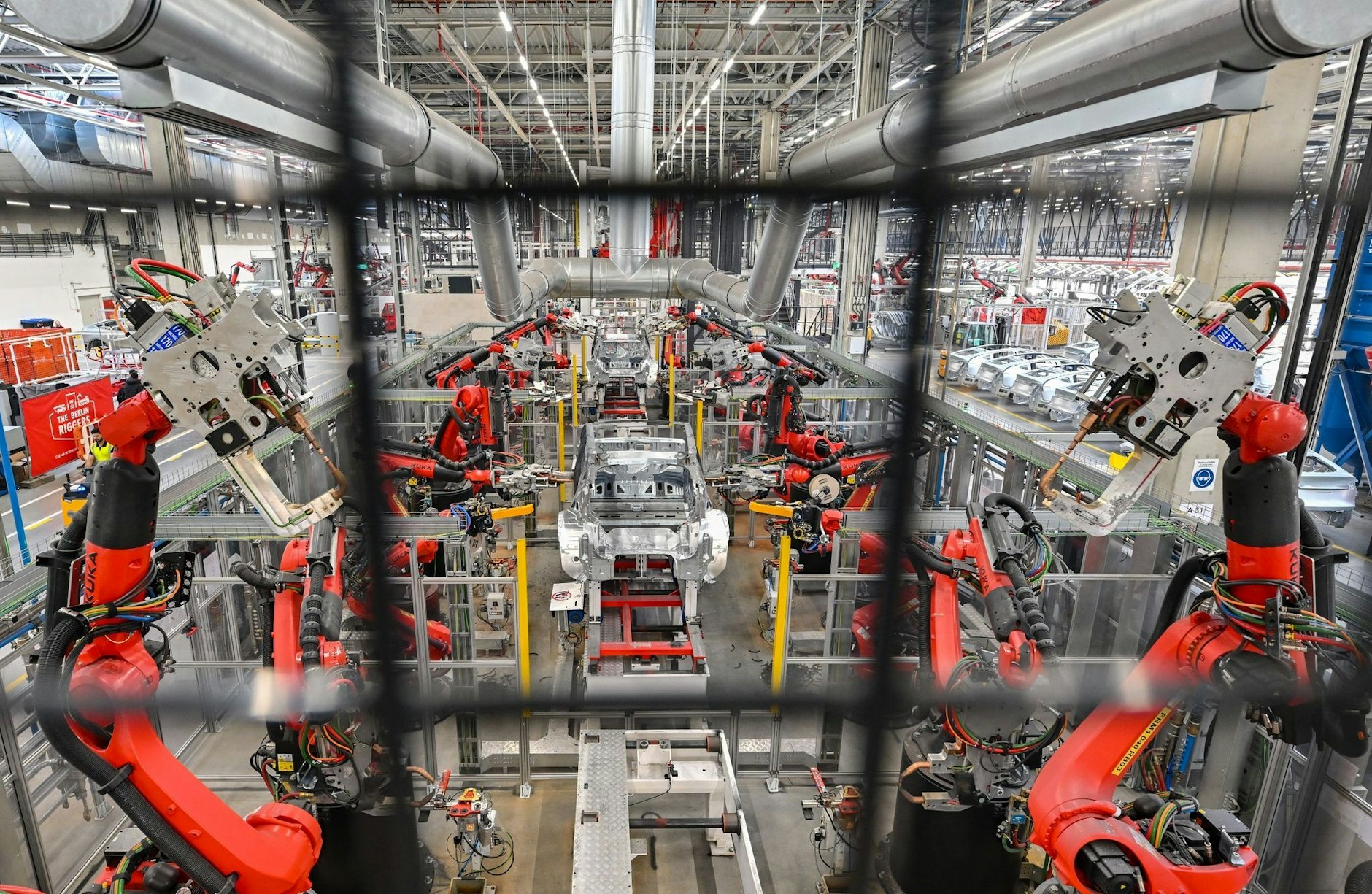 Roboter verschweißen die Karosserie eines Elektrofahrzeuges vom Typ Model Y.  