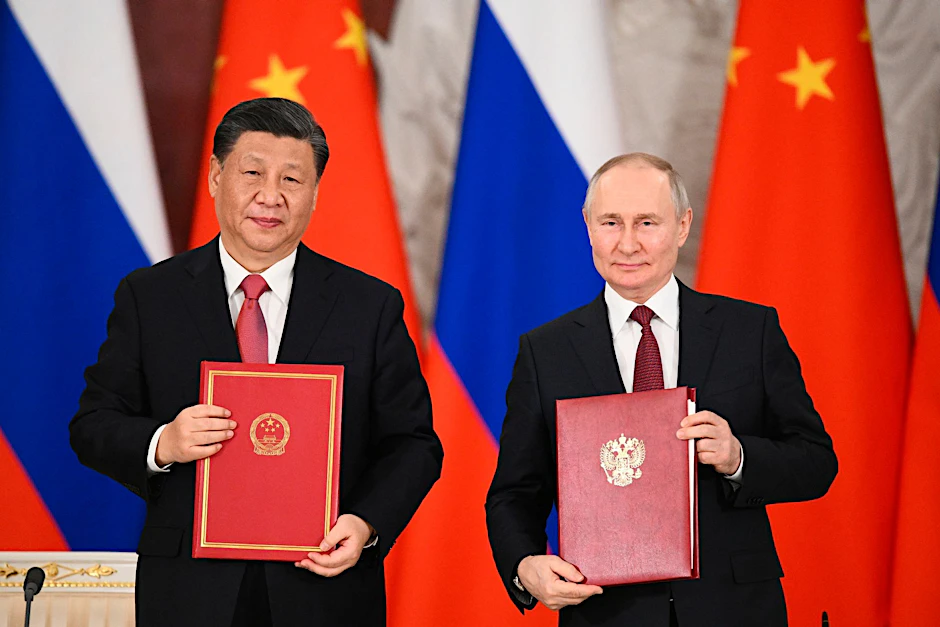 Chinas Präsident Xi Jinping und sein russischer Amtskollege Wladimir Putin zeigen während einer Unterzeichnungszeremonie Mappen mit den neuen Abkommen. 