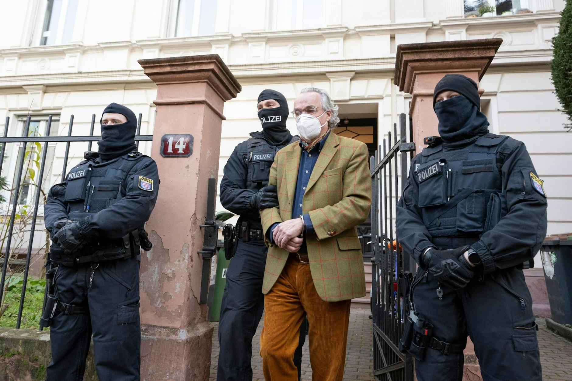 Vermummte Polizisten führen Heinrich XIII Prinz Reuß (2. v. r.) bei einer Razzia gegen sogenannte „Reichsbürger“ in Frankfurt/Main zu einem Polizeifahrzeug. 