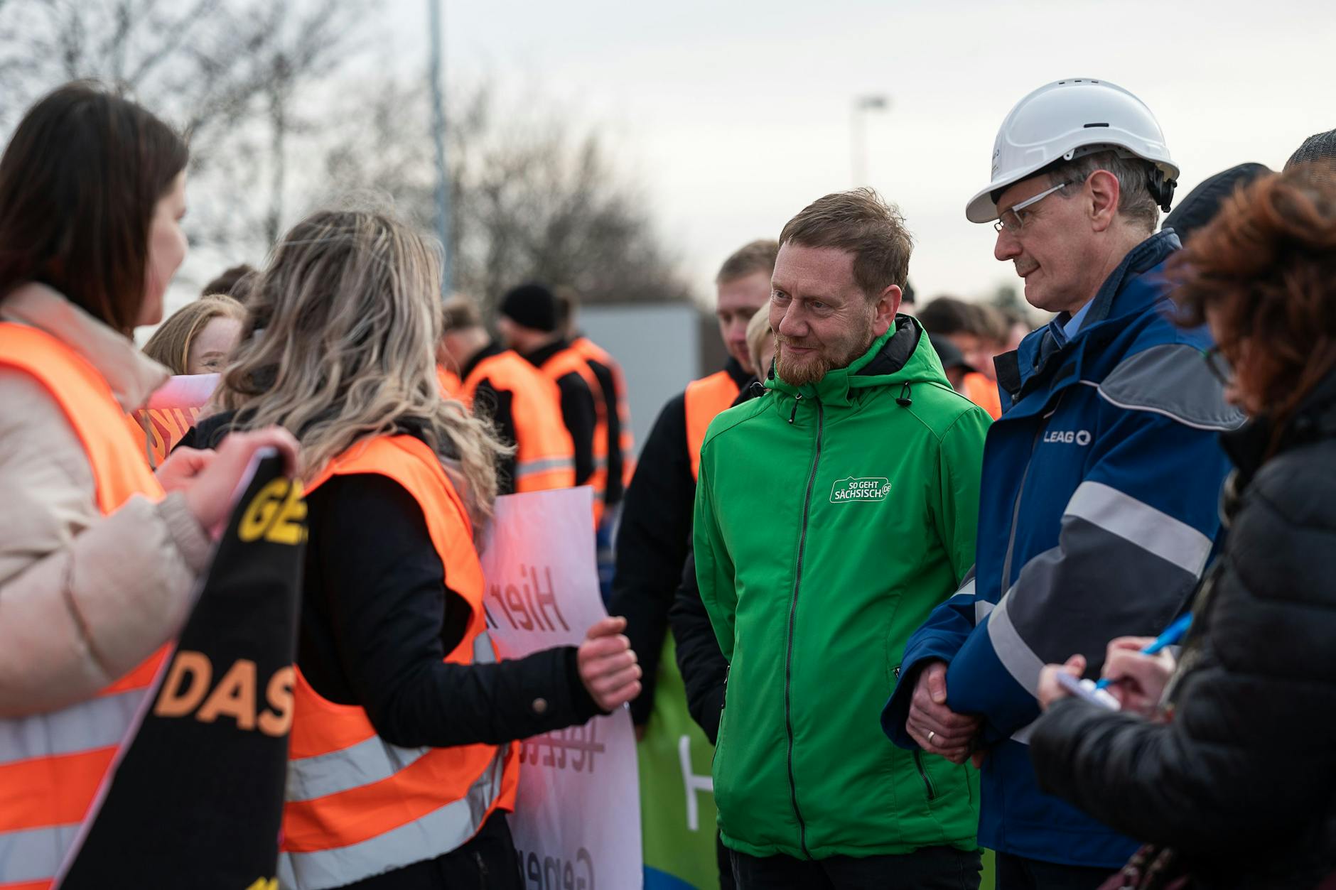 Michael Kretschmer (CDU, M.), Ministerpräsident von Sachsen, unterhält sich mit Auszubildenden der Lausitz Energie Bergbau AG (Leag).