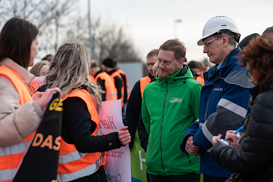 Michael Kretschmer (CDU, M.), Ministerpräsident von Sachsen, unterhält sich mit Auszubildenden der Lausitz Energie Bergbau AG (Leag).