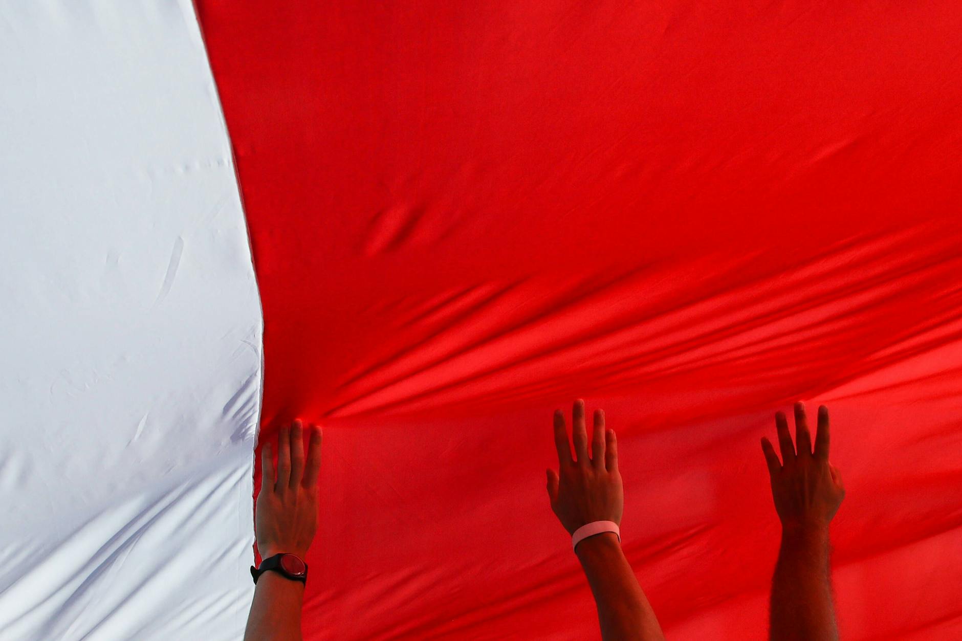 Belarussen riskieren drakonische Strafen, wenn sie die weiß-rot-weiße Fahne hissen.