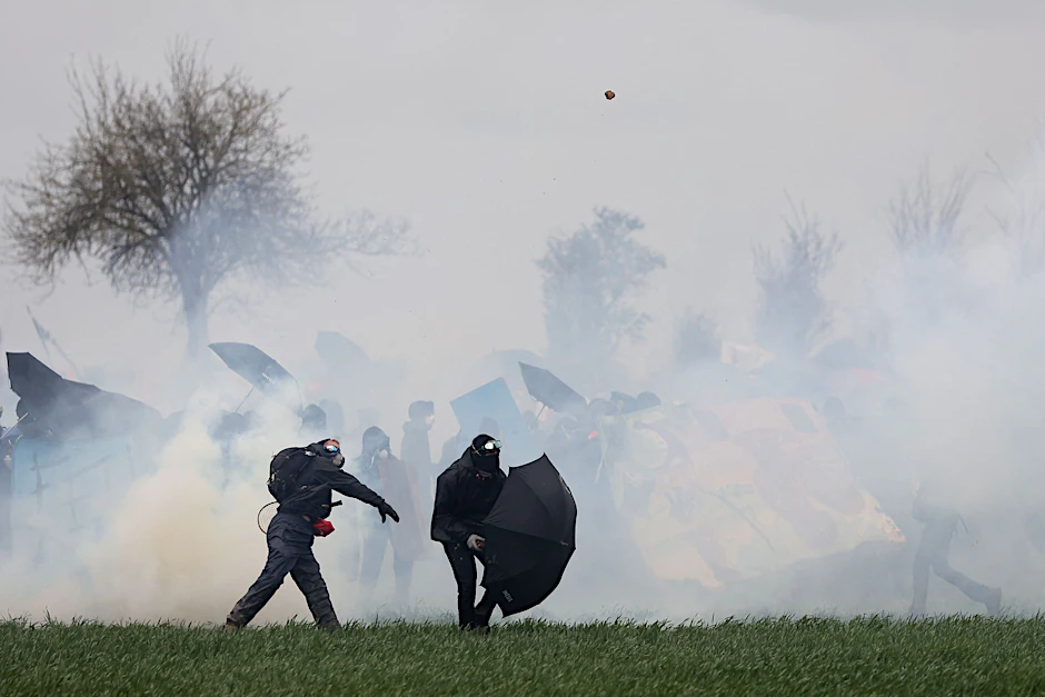 Von Tränengas umzingelte Demonstranten stoßen mit der Polizei zusammen.&nbsp;