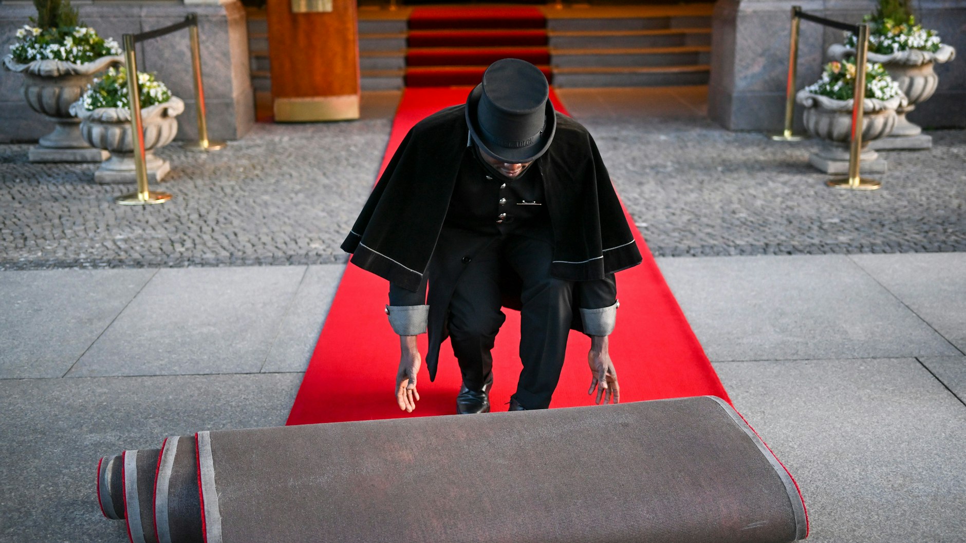 Doorman Timothy Uhunamure rollt vor dem Hotel Adlon den roten Teppich aus. Das wird er diese Woche wohl auch für König Charles III. machen.
