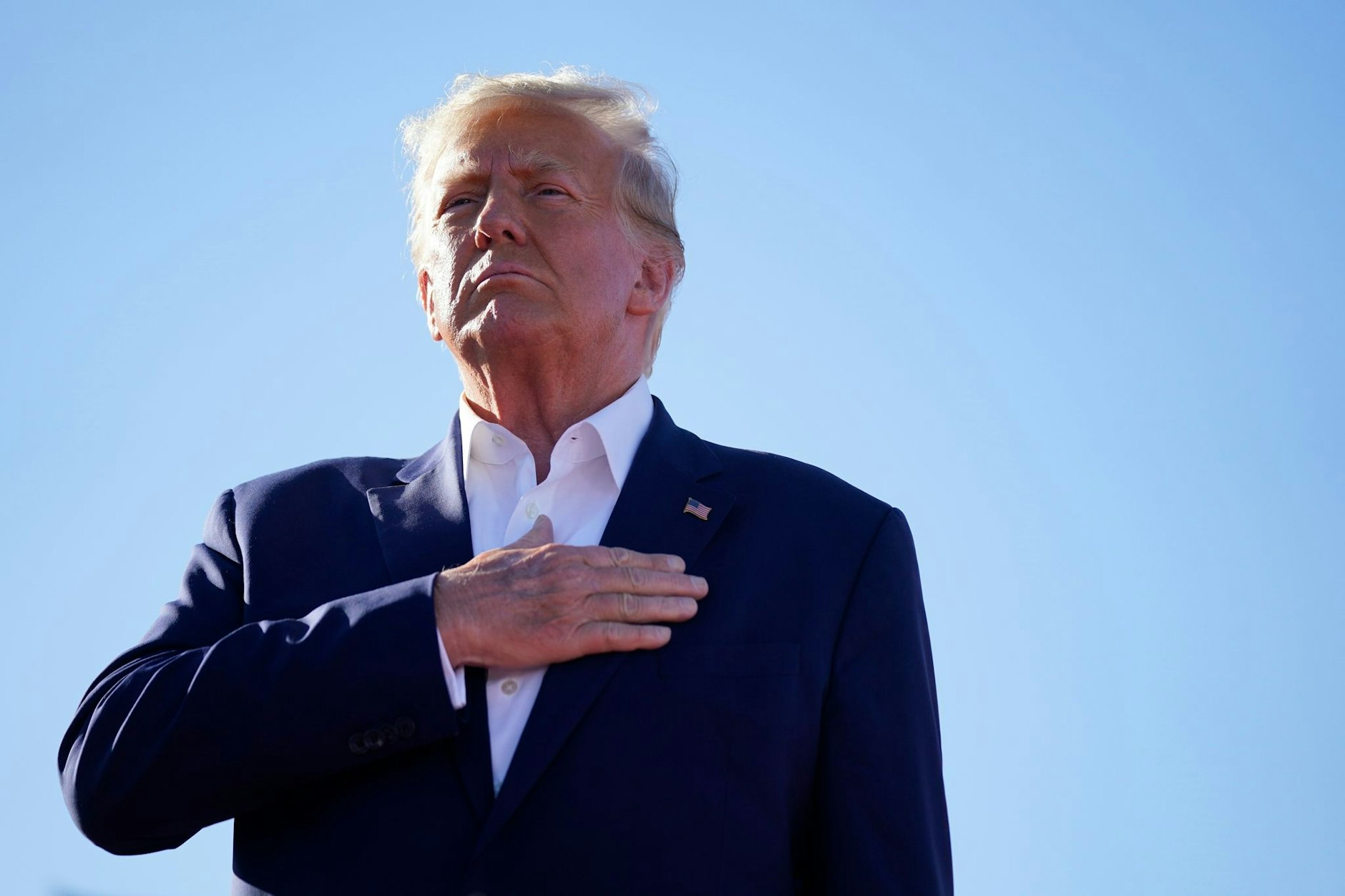 Der ehemalige US-Präsident Donald Trump steht bei der Nationalhymne bei einer Wahlkampfveranstaltung auf dem Waco Regional Airport in Texas.  