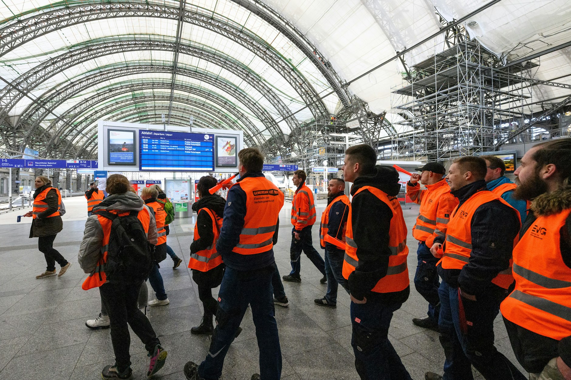 Teilnehmer des Warnstreiks laufen durch den Hauptbahnhof von Dresden.