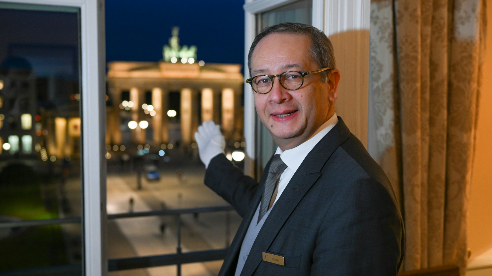 Butler Ricardo Dürner steht in der Royal Suite im Hotel Adlon und präsentiert den Ausblick auf das Brandenburger Tor, den König Charles III. von hier wohl genießen dürfte.