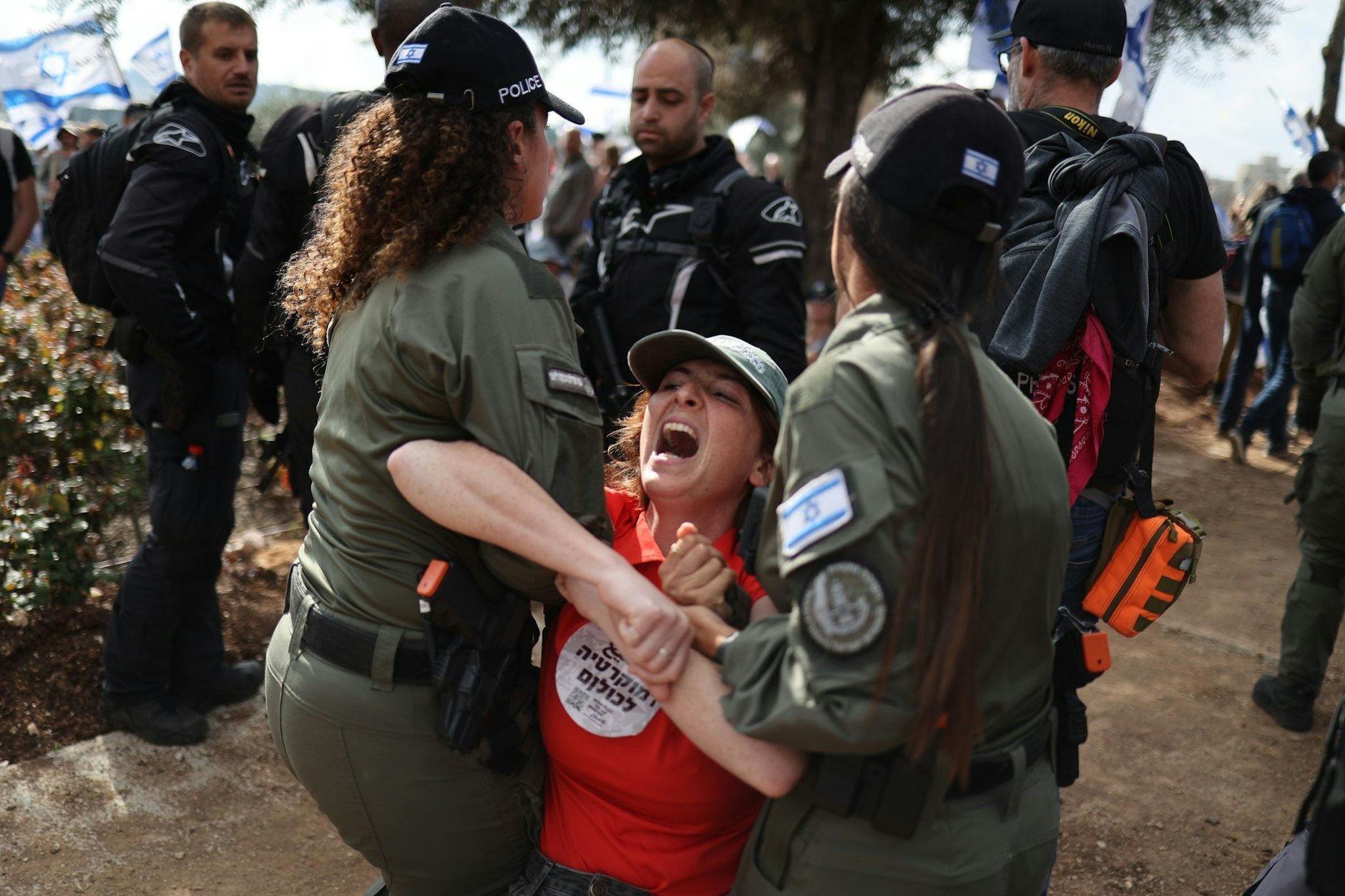 Polizistinnen nehmen in Jerusalem eine Demonstrantin fest.  